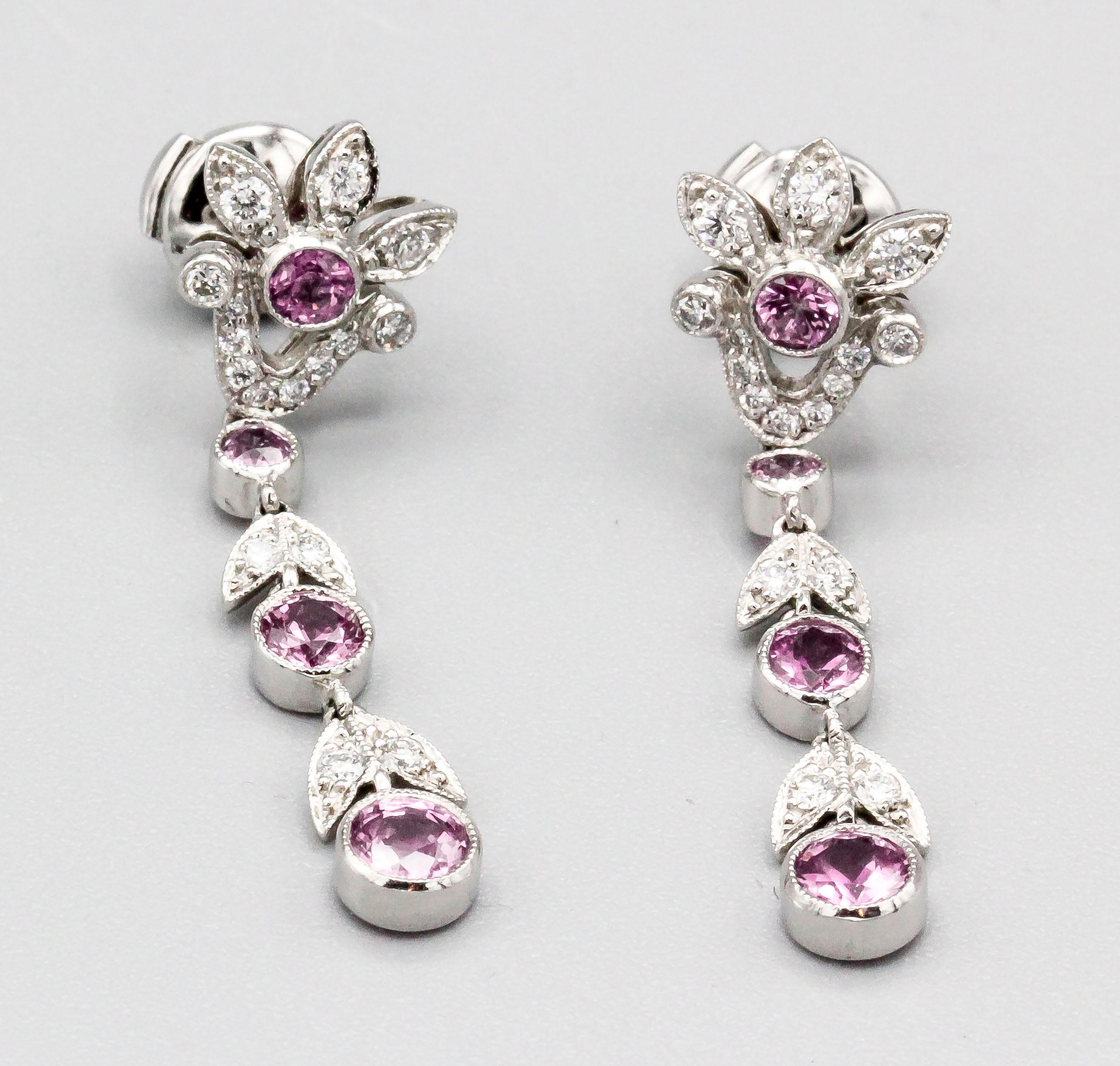 Fine pair of diamond, pink sapphire and platinum ear pendants by Tiffany & Co. The earrings feature a foliage design with approx. 1.5 carats of pink sapphires and .75 carats of round white diamonds.  With original box.

Hallmarks: T & Co., PT950.
