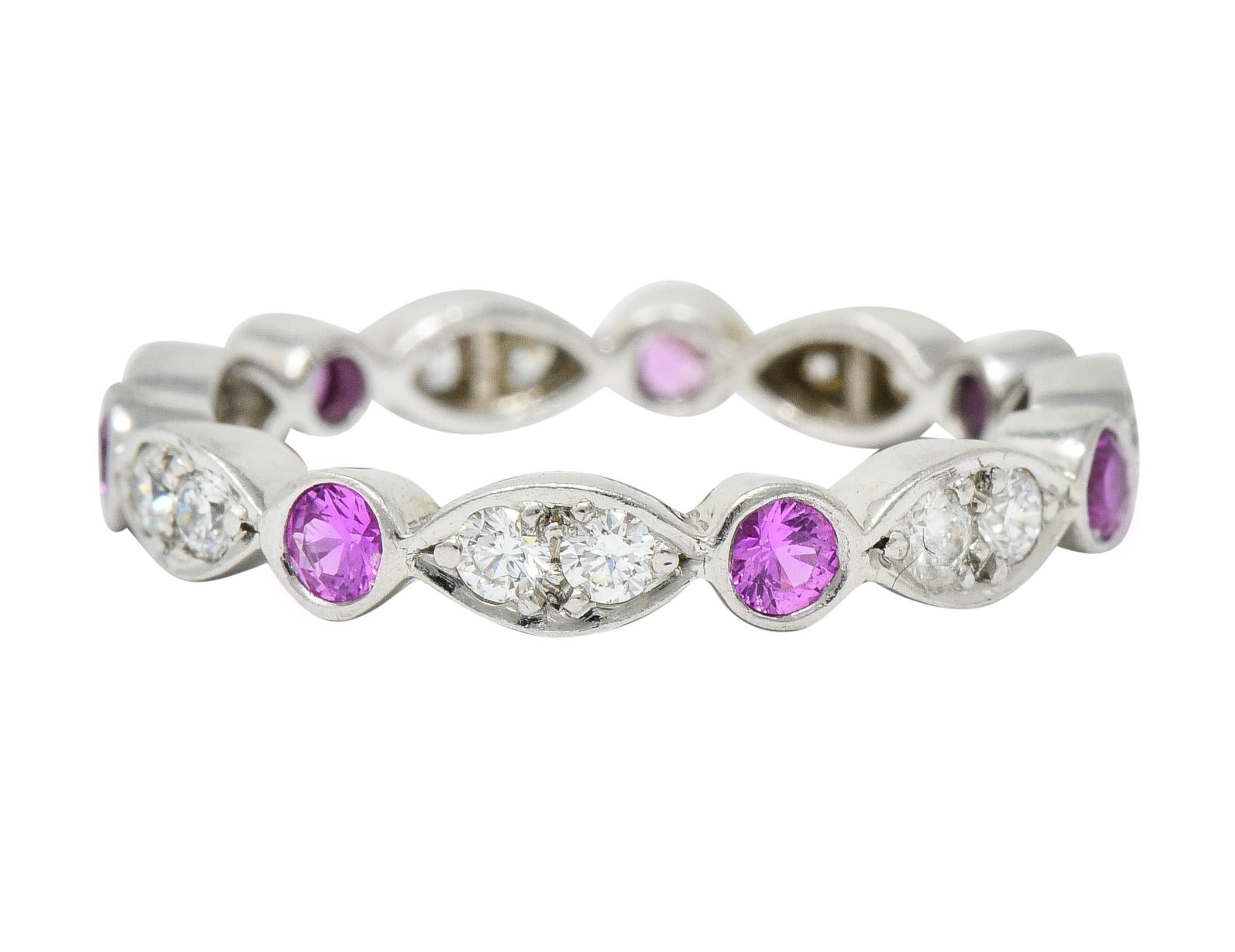 Eternity band ring is designed by diamond set navette forms

Alternating with round bezels of pink sapphire

Total diamond weight is approximately 0.35 carat with F/G color and VS clarity

Sapphires are well-matched and weigh in total approximately