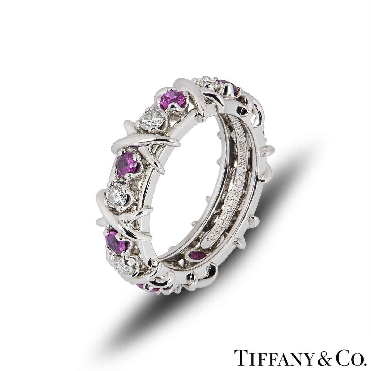 A diamond and pink sapphire Schlumberger ring in platinum by Tiffany & Co. The ring is set with 8 round brilliant cut diamonds totalling 0.59ct and 8 round cut pink sapphires totalling 0.75ct. The ring is a size UK O½ - EU 55½ - US 7.25, measures