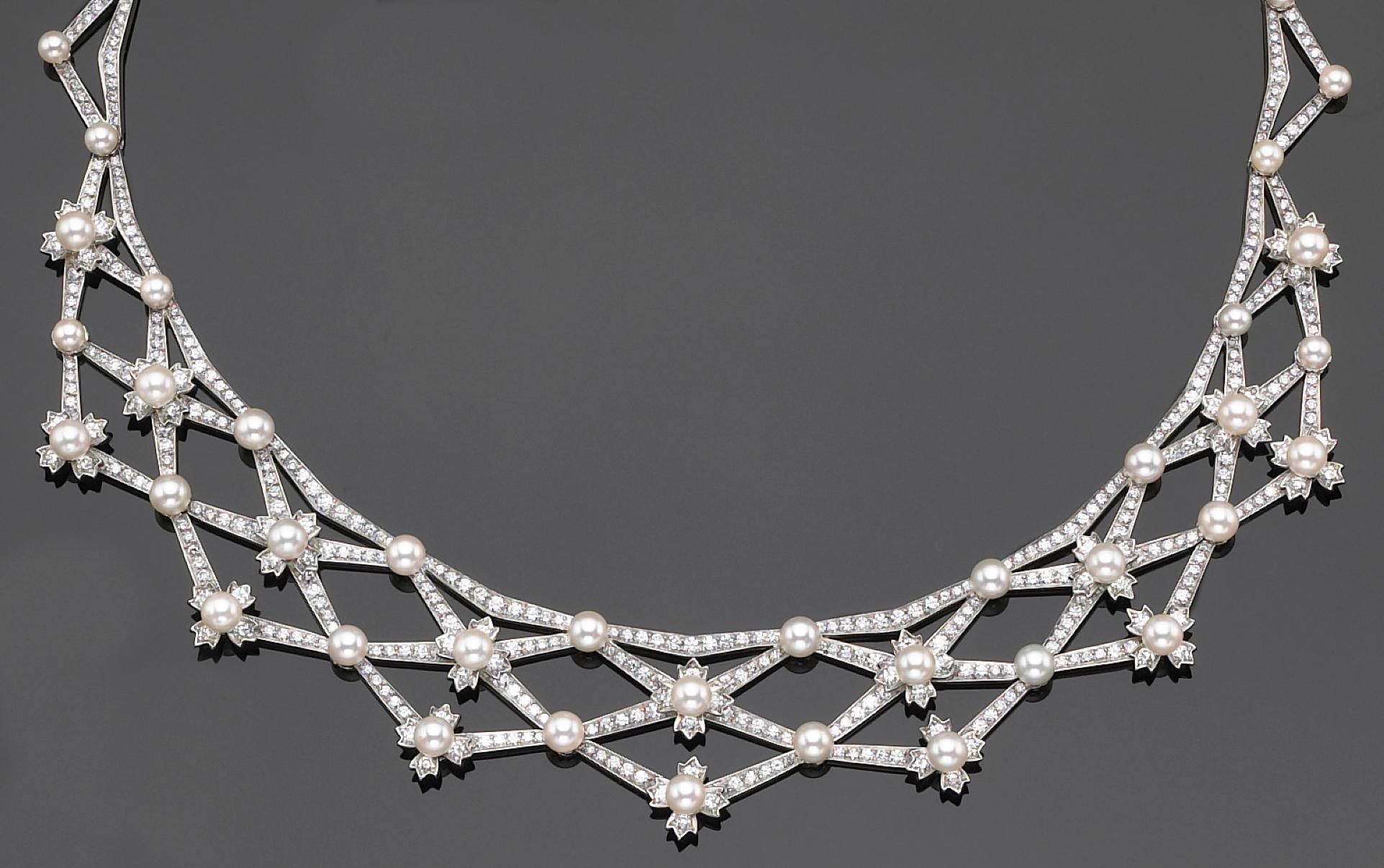 This original Tiffany's necklace features a flexible, delicate lattice design, comprising of fifty-five cultured pearls, measuring approximately 4.35 to 3.50mm., each larger pearl surmounting a diamond-set floret, set throughout with round,