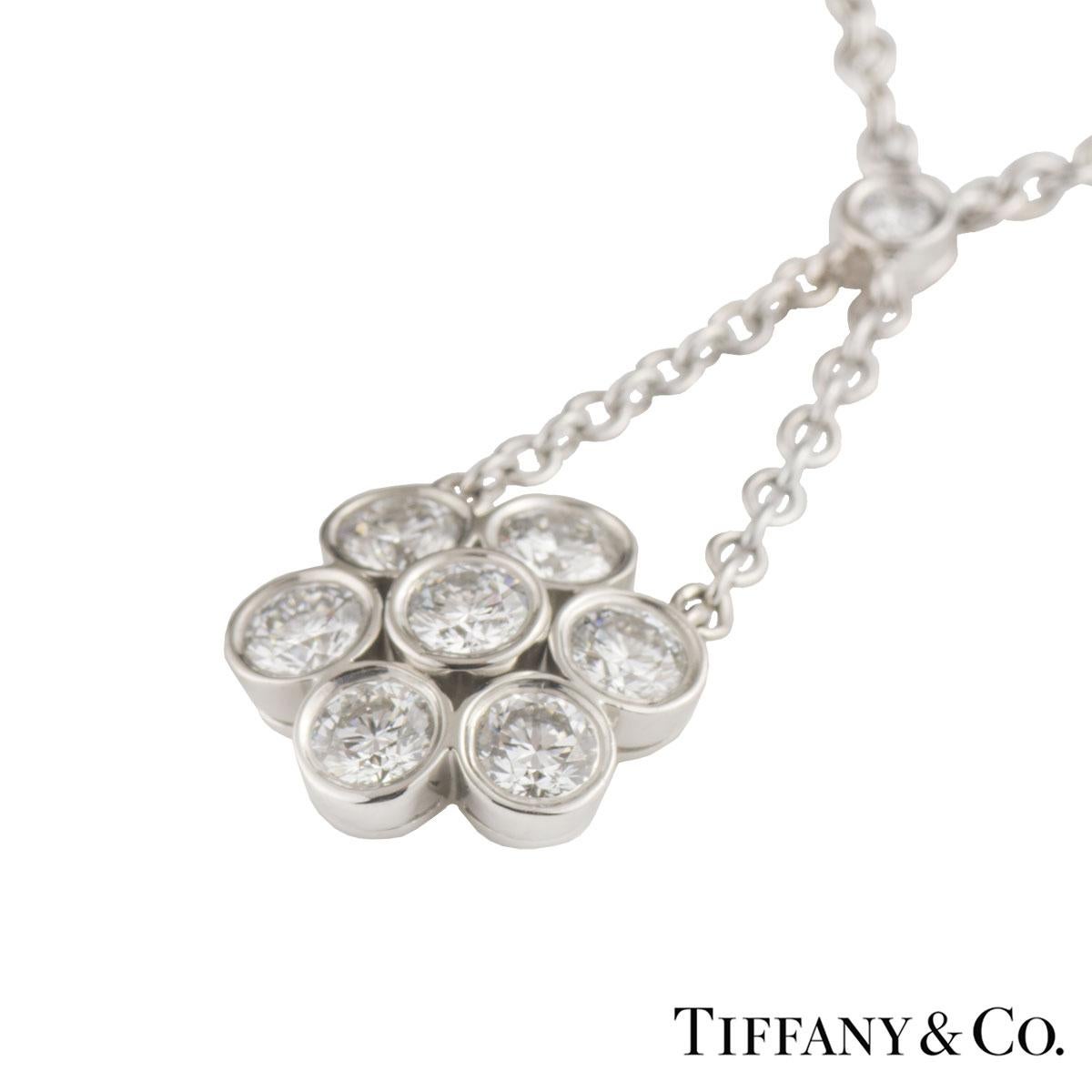 A beautiful platinum diamond Tiffany & Co. pendant from the Enchant collection. The pendant comprises of a flower motif with 7 round brilliant cut diamonds accentuated with two chains joining another round brilliant cut diamond in a rubover setting.
