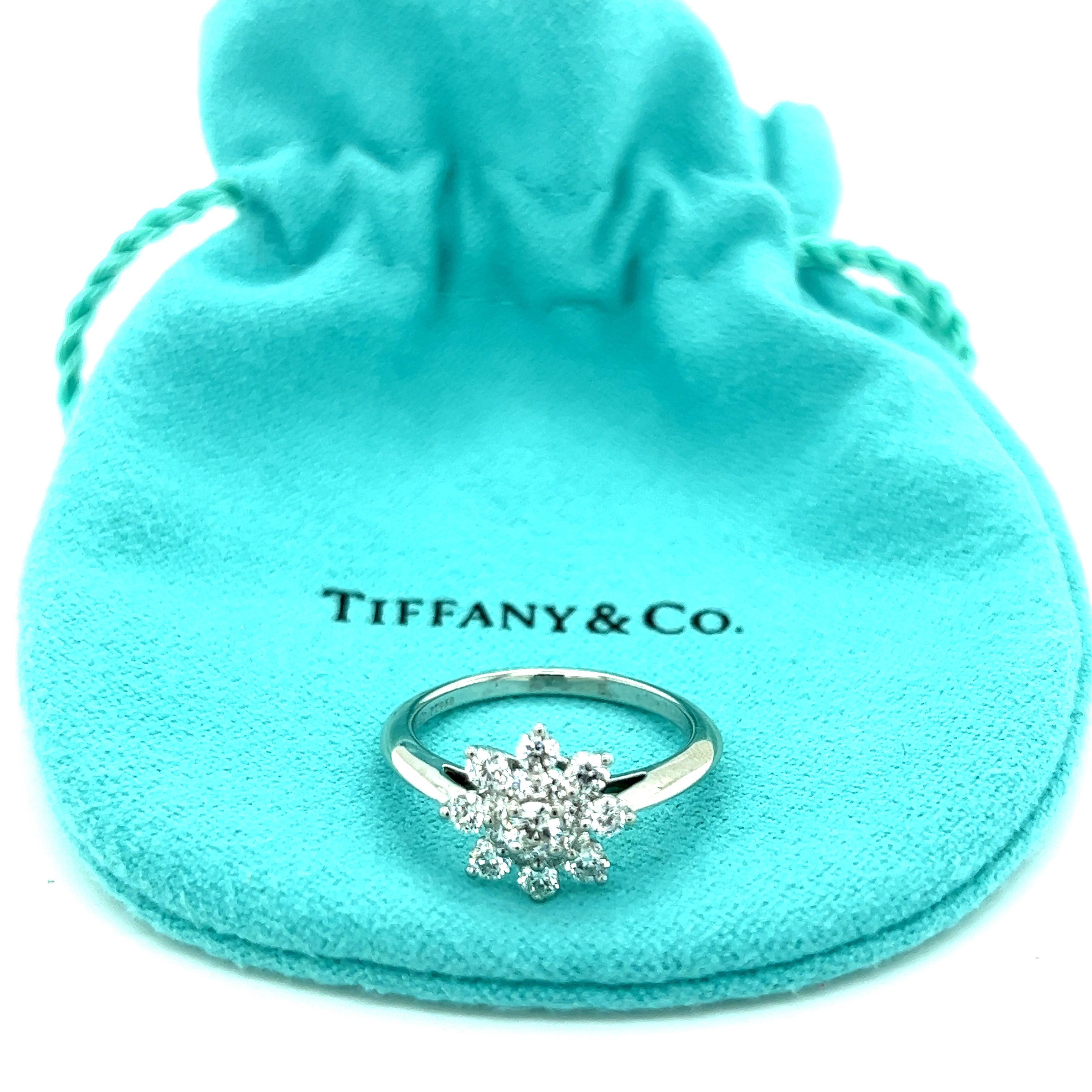 Dieser wunderschöne, authentische Ring ist von Tiffany & Co. Gefertigt aus Platin mit niedrigem Steg und messerscharfem Schaft an einem sich verjüngenden Band. Der obere Teil der Brücke ist mit einer schönen Blume in Form einer Schneeflocke