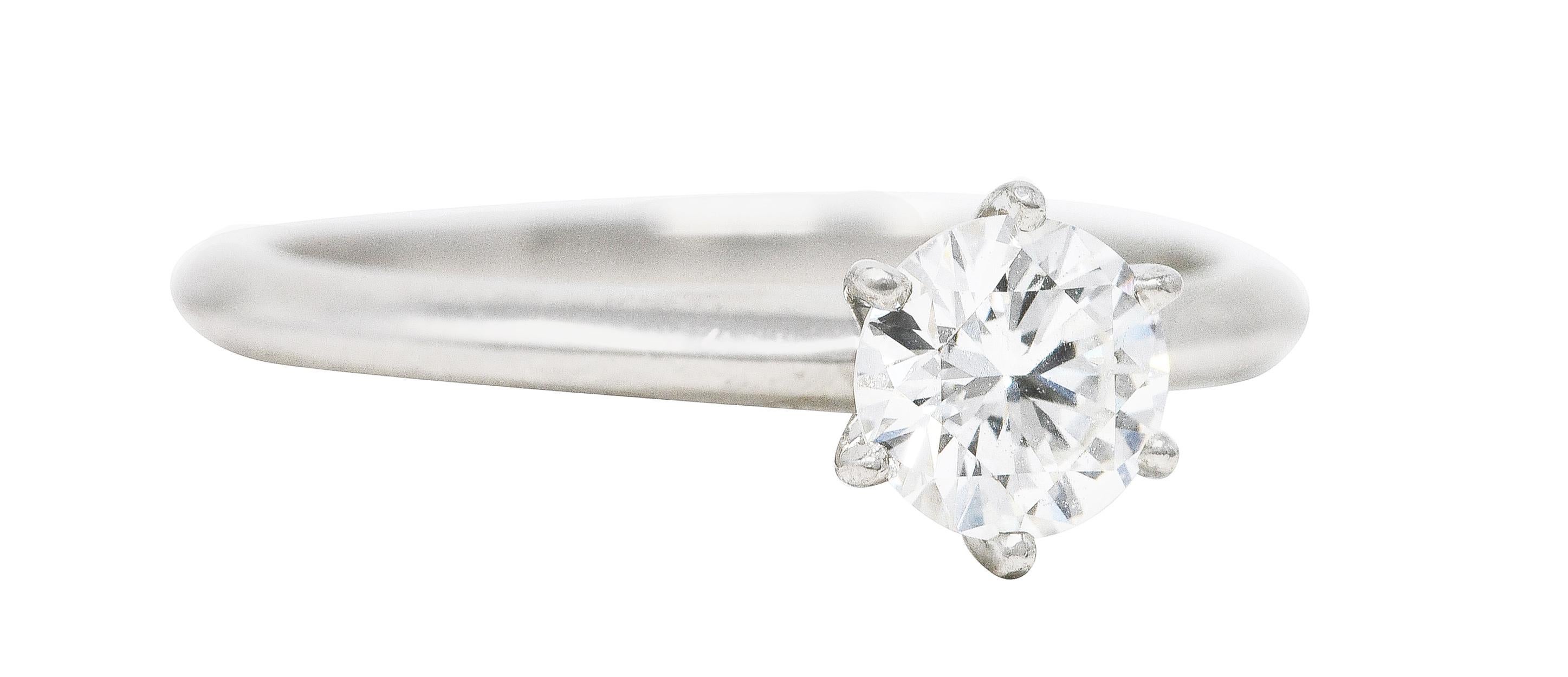 In der Mitte ein runder Diamant im Brillantschliff mit einem Gesamtgewicht von 0,77 Karat - Farbe G und Reinheit SI1. In einer klassischen Fassung im Tiffany-Stil mit sechs Zacken gefasst. Akzentuiert durch den hochglanzpolierten Messerschaft.