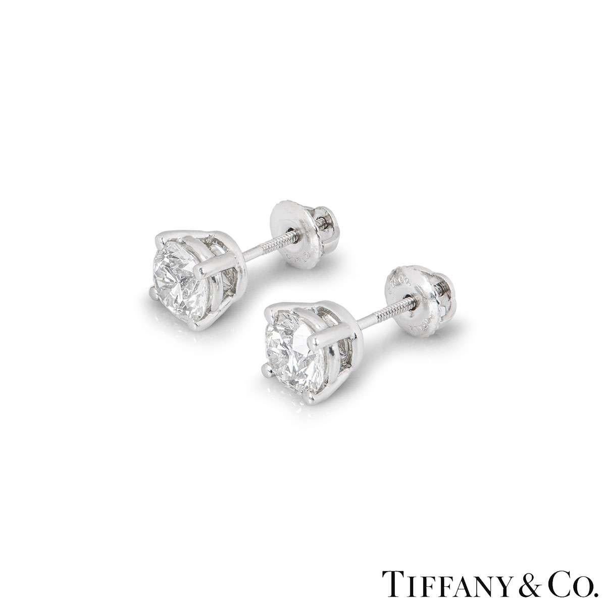 A stunning pair of platinum diamond ear studs by Tiffany & Co. Each earring is set with a round brilliant cut diamond in a four claw setting. Both diamonds have a weight of 1.01ct and are both H colour, one diamond is VS1 clarity and the other is