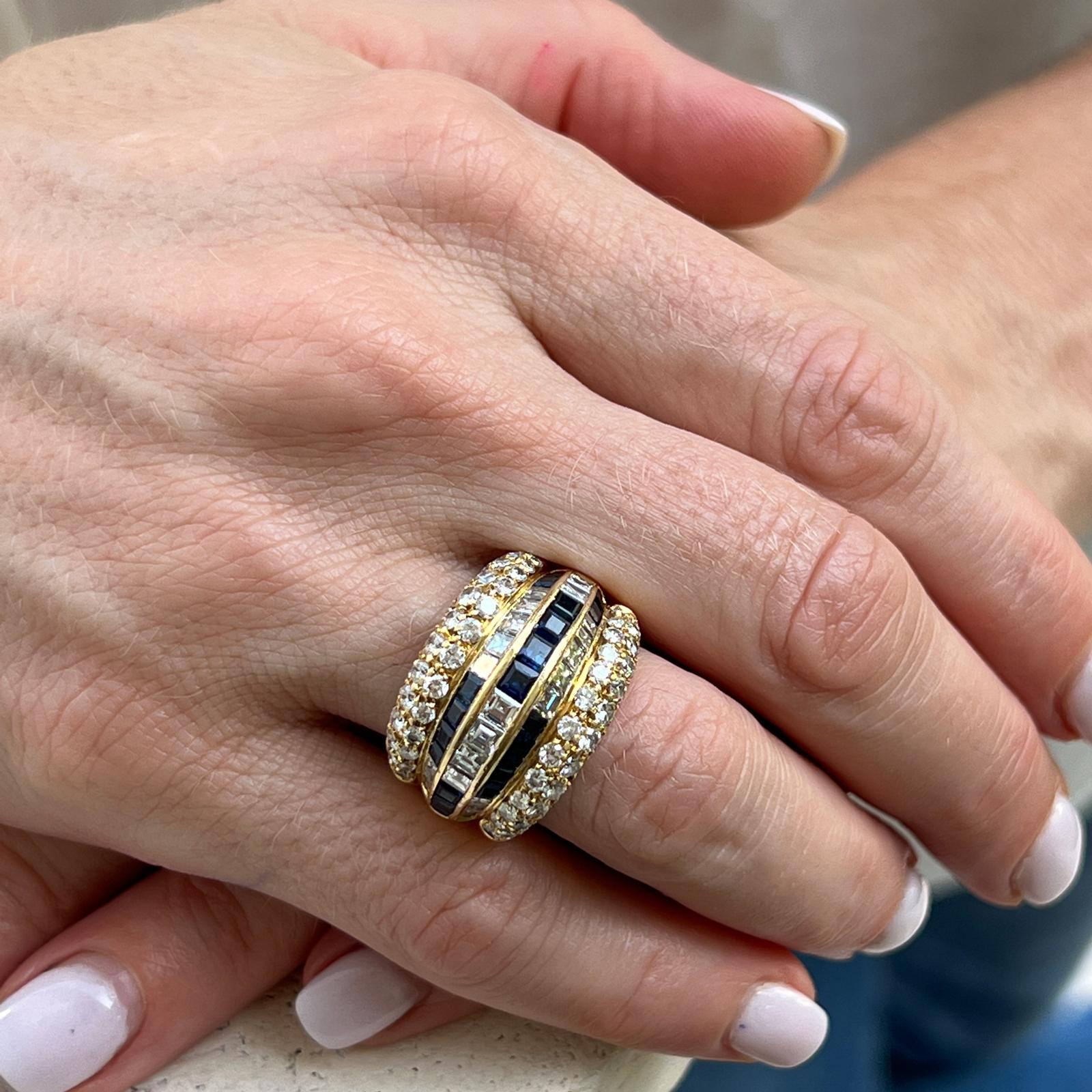 Fabulous Vintage Tiffany & Co. sapphire and diamond ring beautifully crafted in 18 karat yellow gold. The wide band features round and square emerald cut diamonds weighing approximately 3.40 CTW and graded F-G color and VS clarity. Square cut