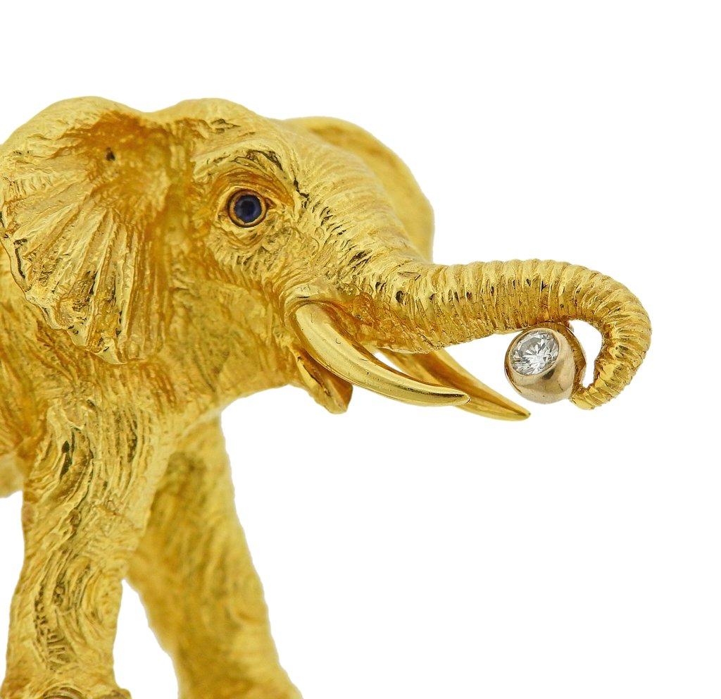 Tiffany & Co 18k gold elephant brooch, set with sapphire eyes and approx. 0.05ct G/VS diamond. Brooch is 49mm x 29mm. Weight is 29.9 grams. Marked Tiffany & Co, 1996, 750, Germany. 