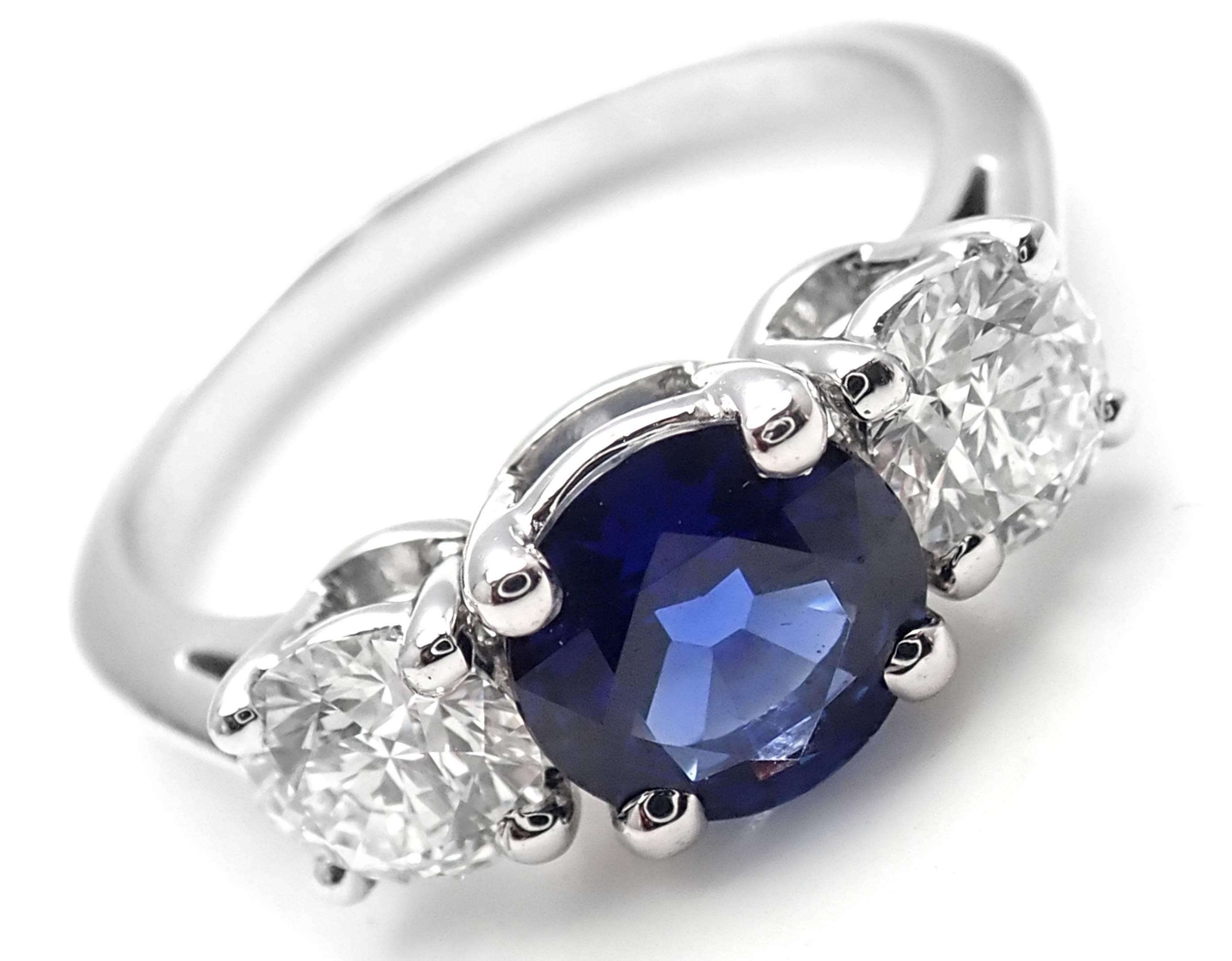 Platinum Diamond And Sapphire Three Stone Band Ring by Tiffany & Co. 
With 2 Round Brilliant Cut Diamonds VS1 clarity, G color, Total weight Approx .82ct
1 round sapphire total weight approx. 1.03ct
Details:
Ring Size: 6
Width: 6mm
Weight: 5