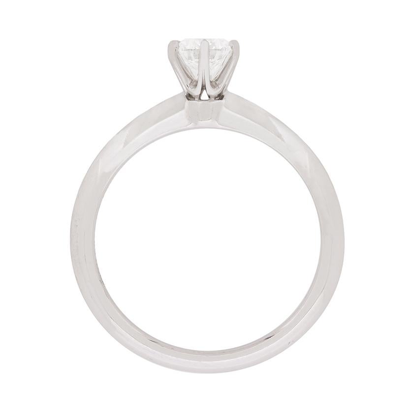 Une bague de fiançailles classique de Tiffany & Co. Il est centré sur un diamant rond de taille brillant qui pèse 0,45 carat. Il est accompagné d'un certificat de Tiffany & Co, qui indique que la qualité est E pour la couleur et SI1 pour la clarté.