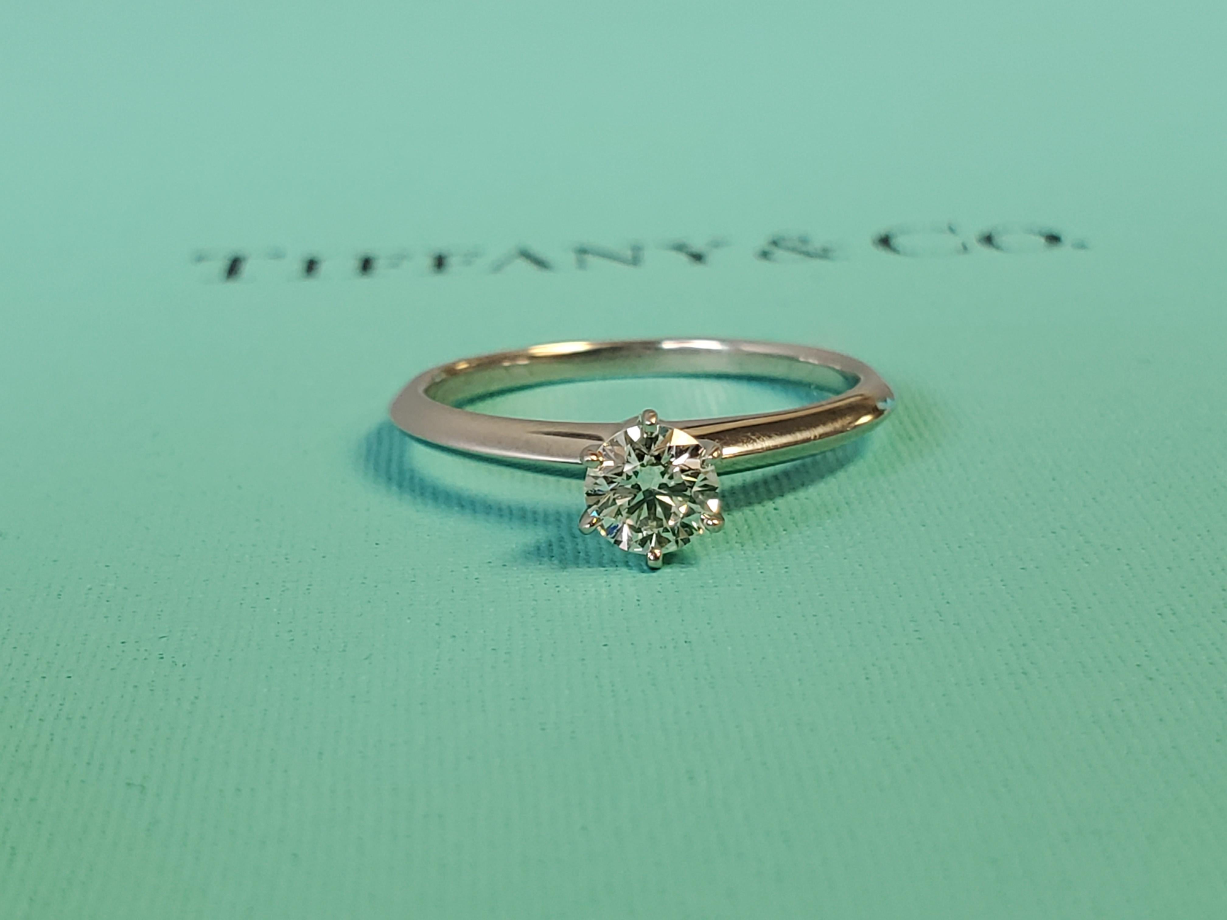 Listed is a like new Tiffany & Co. platinum diamond solitaire engagement ring complete with boxes and papers. I don't believe this ring has ever been worn and it is dated July 23', everything is pristine. The center stone is a .46ct I VS1 round