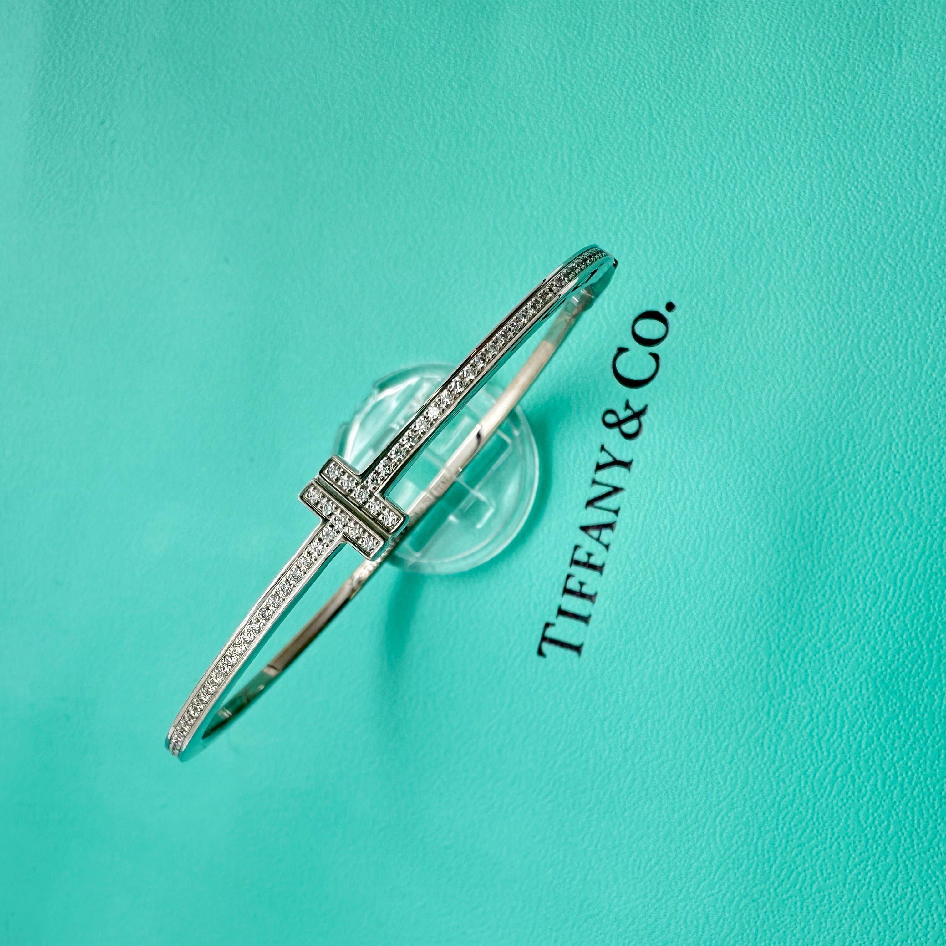 TIFFANY & CO. Bracelet en fil métallique à charnière Diamond T 
Le style :  Bracelet
Numéro de référence :  62273119
Métal :  AT&T
Taille / Mesures :  6.5' Inches / 2.24 mm - 7.16 mm
TCW :  0,33 tcw
Le diamant principal :  74 diamants ronds et