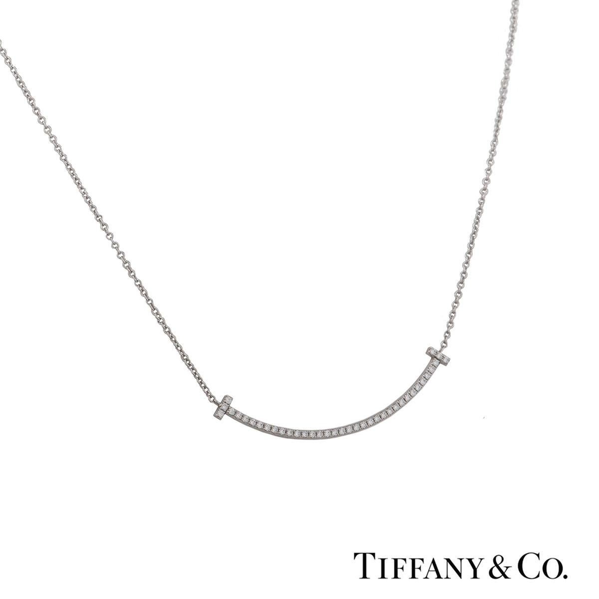 A beautiful 18k white gold diamond pendant by Tiffany & Co. from the Tiffany T collection. The pendant comprises of a smile motif set with round brilliant cut diamonds with a total weight of 0.10ct. The pendant features a bolt spring clasp with a