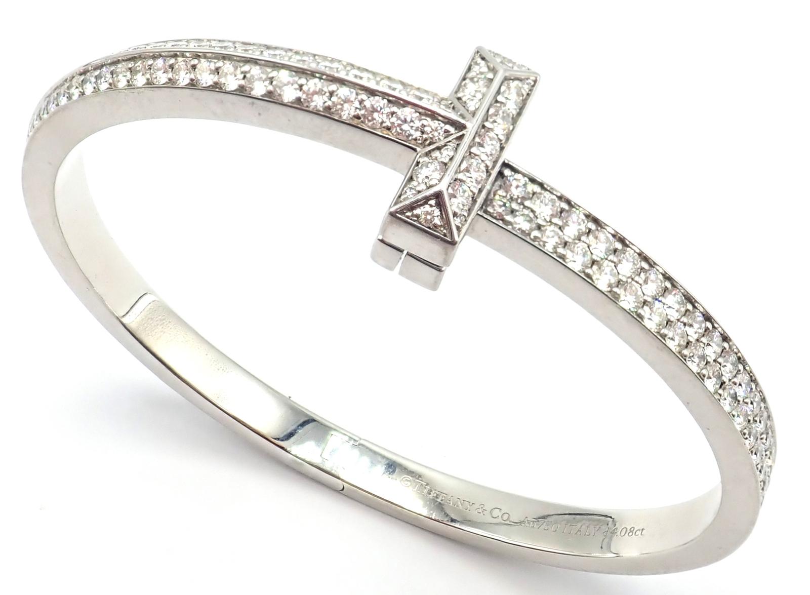 18k White Gold Diamond T1 Wide Hinged Bangle Bracelet by Tiffany & Co. 
With Round Brilliant Diamonds - 4.08ct
This Tiffany & Co T1 wide hinged bangle is exquisitely fashioned in 18k white gold, showcasing a brilliant array of diamonds along the