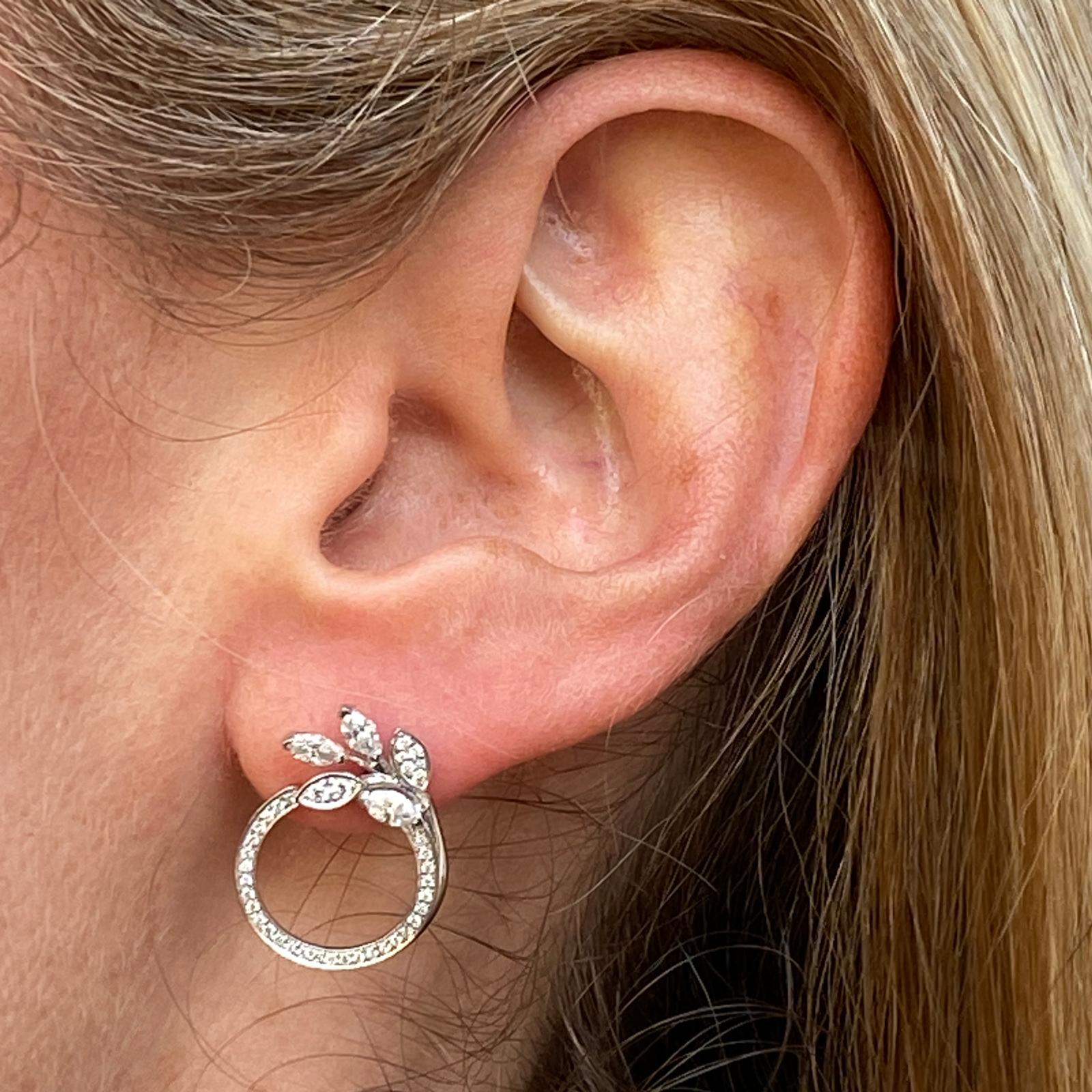 Beautiful diamond vine circle earrings by Tiffany & Company fashioned in platinum. These current earrings feature round brilliant and marquise shape diamonds weighing approximately .81 carat total weight. The earrings measure 15 x 20mm, and feature