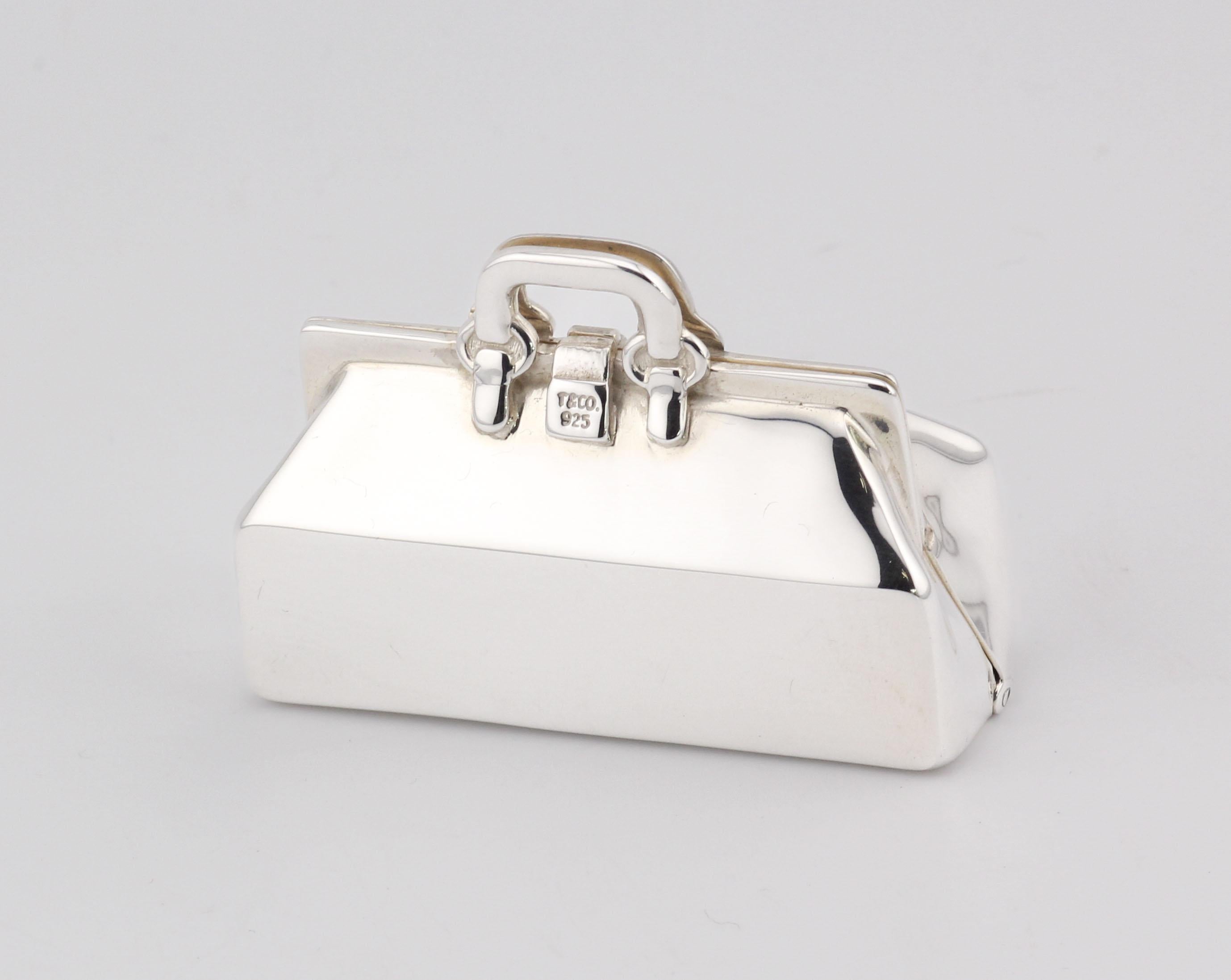 Ti presentiamo la Tiffany & Co. Doctor Bag Sterling Silver Pill Box: uno squisito mix di lusso e funzionalità. Realizzato dalla stimata casa Tiffany & Co. questo portapillole si ispira all'iconica borsa del dottore, trasformandola in un'opera d'arte