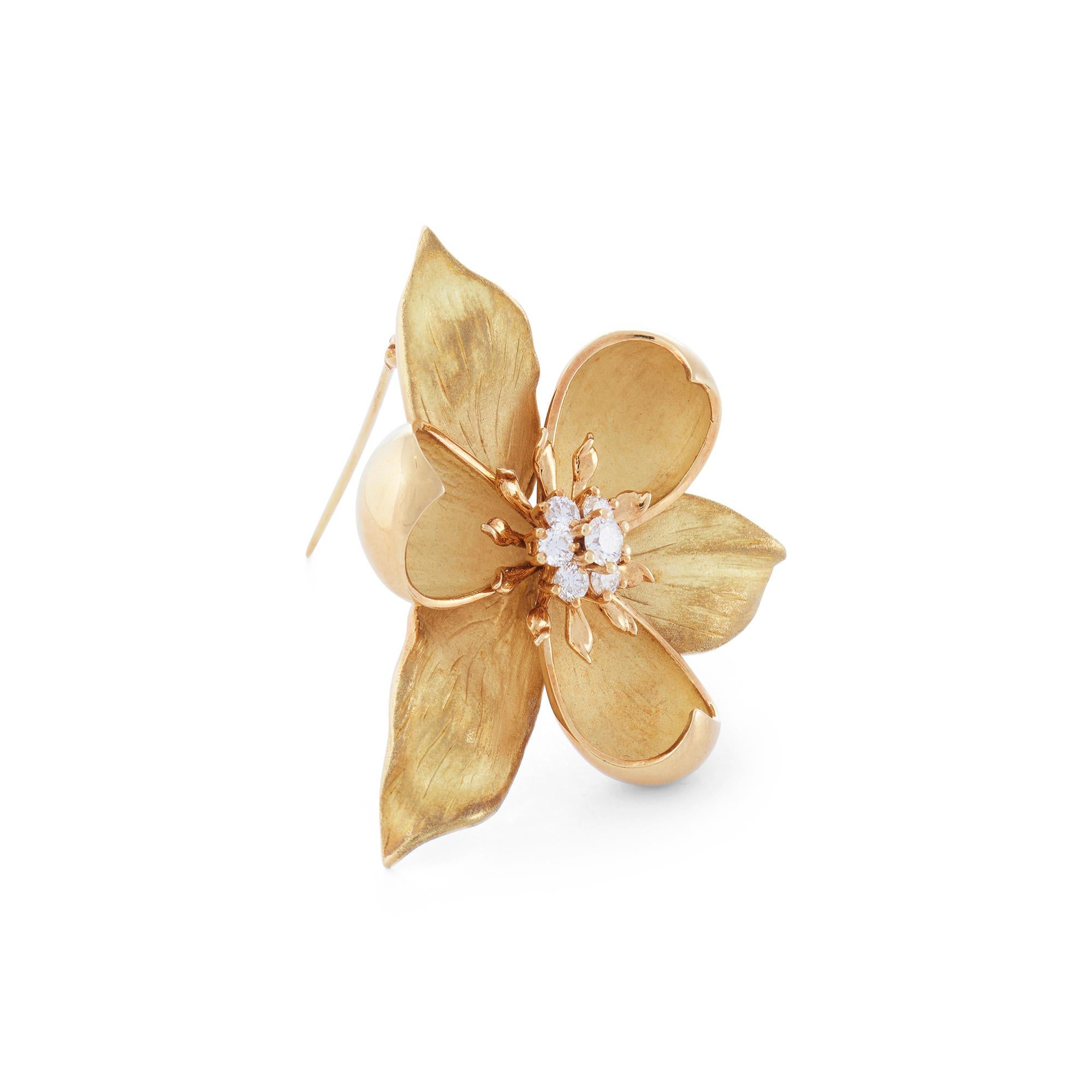 Authentic Tiffany & Co. brooch from the iconic Dogwood collection crafted in 18 karat yellow gold. The petals are sculpted in brushed and polished gold, and are accented with seven round brilliant cut diamonds (F-G/VS) weighing an estimated 0.55