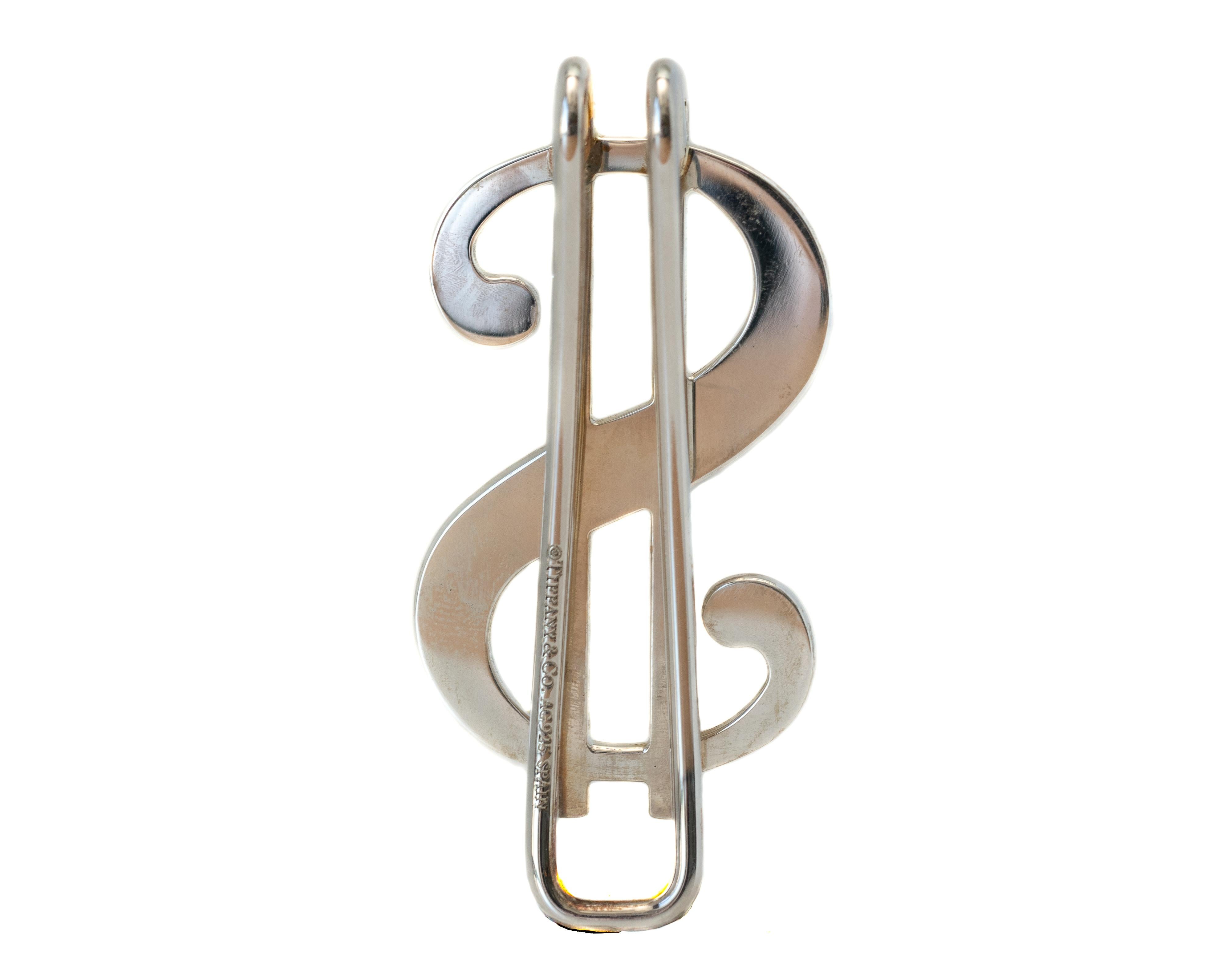 Tiffany & Co. Dollar Sign Money Clip - Sterling Silver

Features:
Polished Sterling Silver
from Tiffany & Co. Spain
Measures approximately 5.25  x 2.5 centimeters
May be Engraved 
Modern, Bold and Sleek Design
Art and Function meet in this Stylish