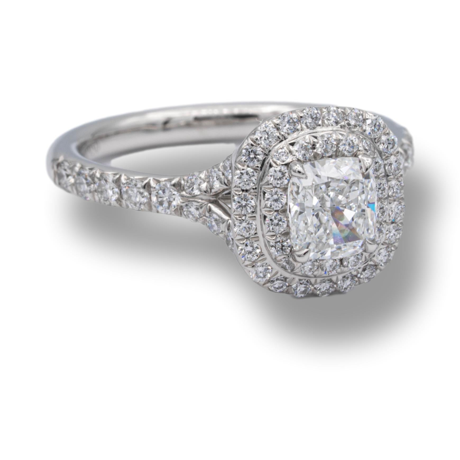 Tiffany & Co. Soleste engagement ring with a .51 ct cushion center , F Color, VS1 clarity finely crafted in platinum, accented by a double row halo design with round brilliant cut bead set diamonds weighing 0.30 carats approximately in the D-F color