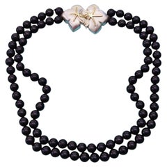 Tiffany & Co. Collar de dos vueltas con cuentas negras, cierre floral y estrella de mar de oro de 18k