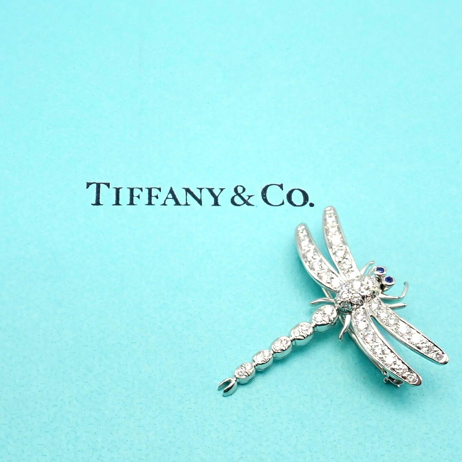 Platinum Diamond & Sapphire Dragonfly Brooch Pendant by Tiffany & Co. 
Rare and authentic Tiffany & Co. dragonfly brooch, masterfully crafted in platinum. 
This exquisite piece showcases shimmering diamonds complemented by vibrant sapphires,