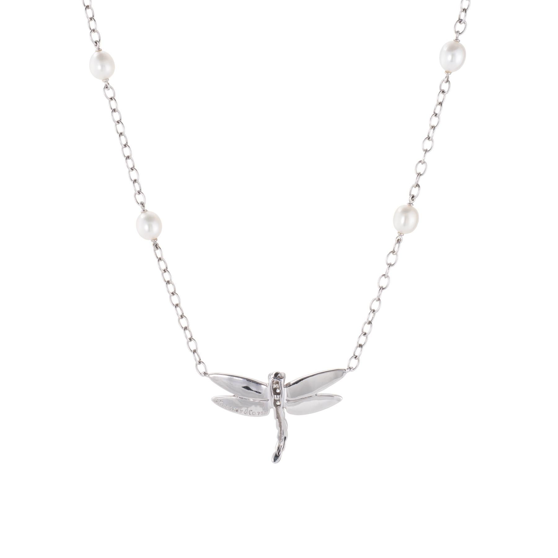 Elegant Tiffany & Co dragonfly necklace, crafted in 18 karat white gold.  

Diamonds total an estimated 0.10 carats (estimated at F-G color and VVS2 clarity), accented with freshwater cultured pearls that measure 5.5mm each. 

The necklace retailed