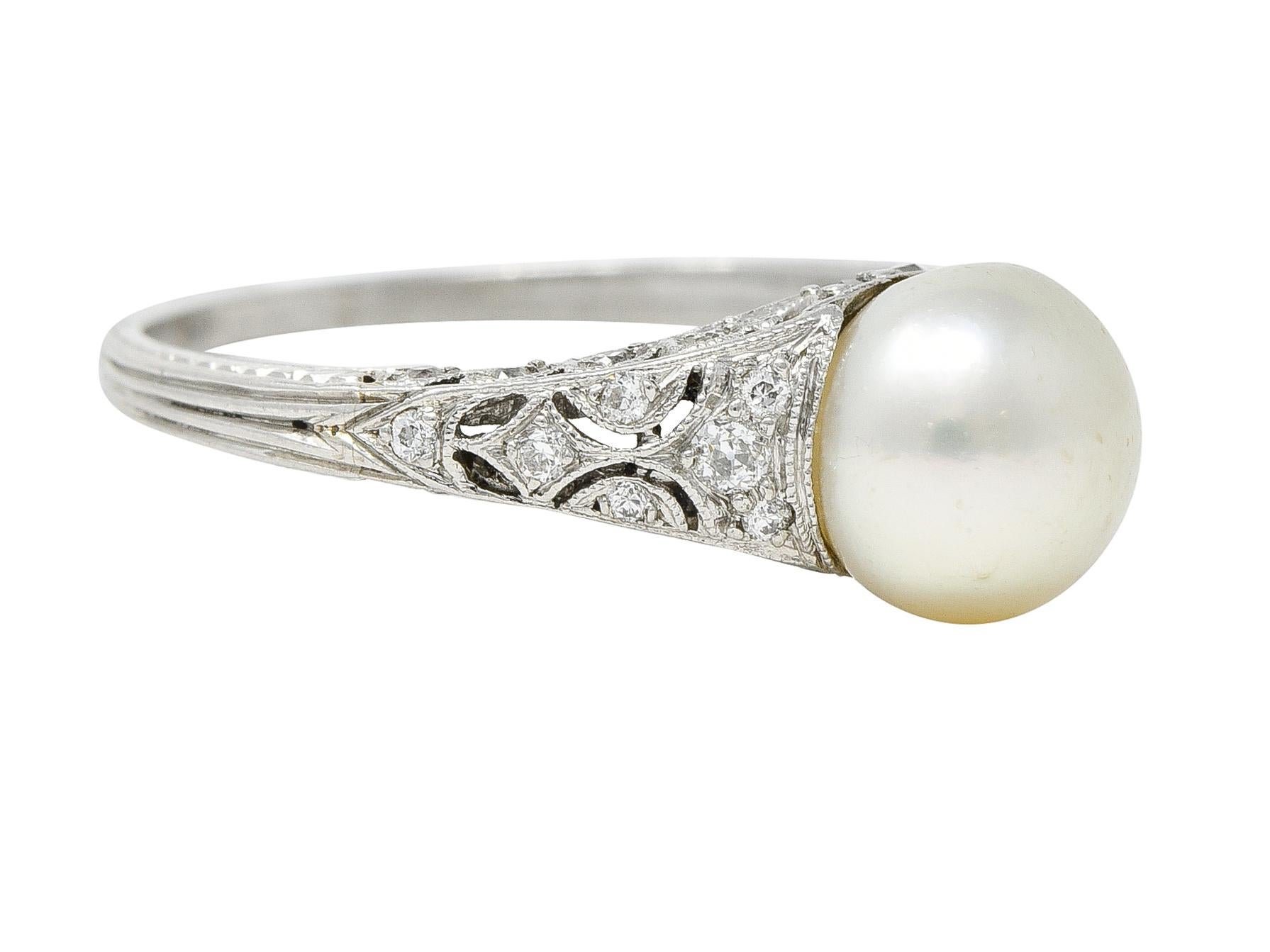 Centering a 7.0 mm round pearl - opaque cream in body color with moderate iridescence. Flanked by pierced geometric shoulders with a pierced scrolling ivy motif gallery. Accented by single and old European cut diamonds bead set throughout. Weighing