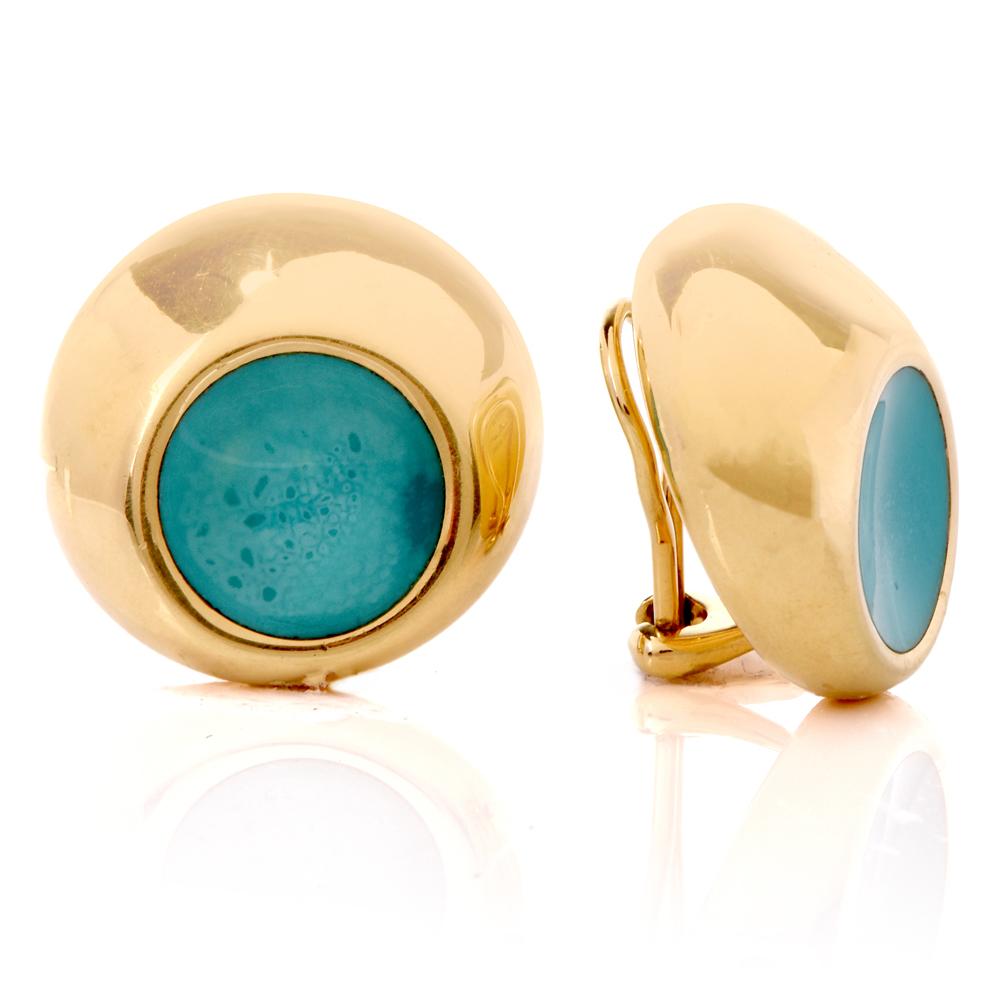 These authentic Tiffany & Co. 1990s clip-back earrings are crafted in 18-karat yellow gold, weighing 21.4 grams and measuring 22 mm in diameter.  Designed as stylized, subtly convex orbicular plaques, they each expose a round enamel décor in an