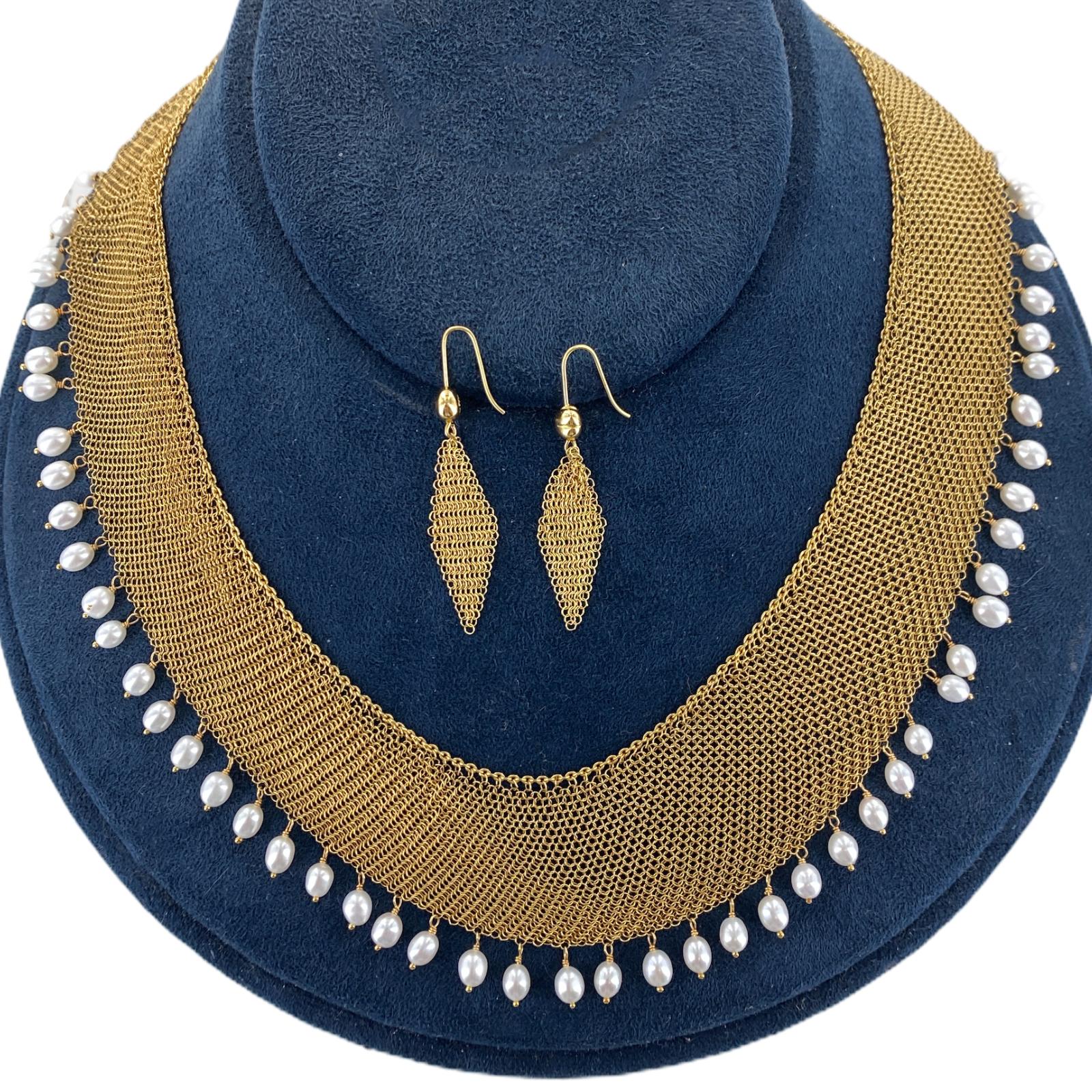 Fabulous necklace and earring set by designer Elsa Peretti for Tiffany & Company. The set is circa 1981 and features mesh 18 karat yellow gold earrings measuring 2 inches in length and .4 inches in width. Signed Peretti 1981. The matching mesh
