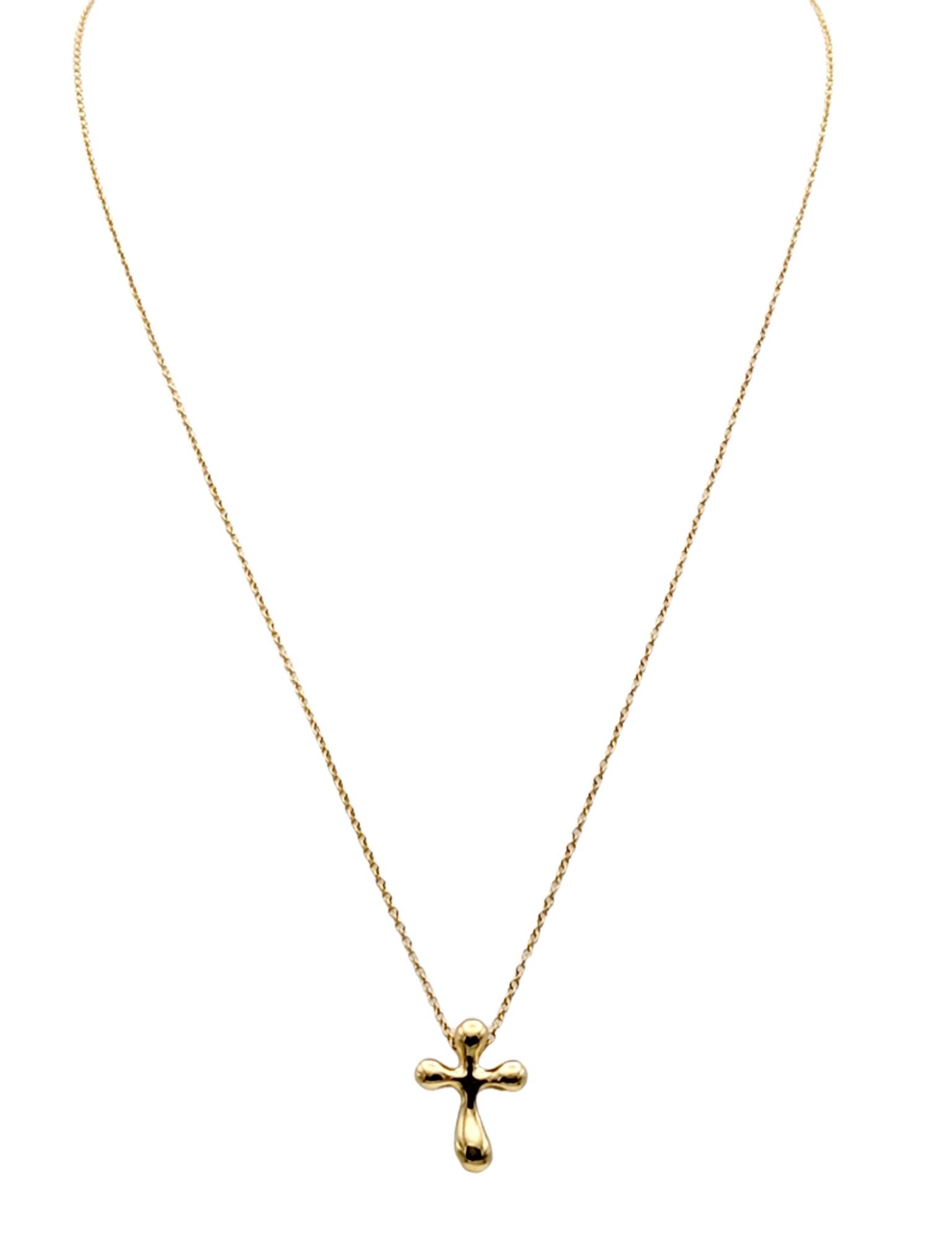 Simply stunning modernized 18 karat yellow gold cross pendant necklace designed by Elsa Peretti for Tiffany & Co.. This keepsake is truly a classic that will never go out of style. 
  
Metal: 18K Yellow Gold
Length: 16”
Cross width: 12 mm
Cross