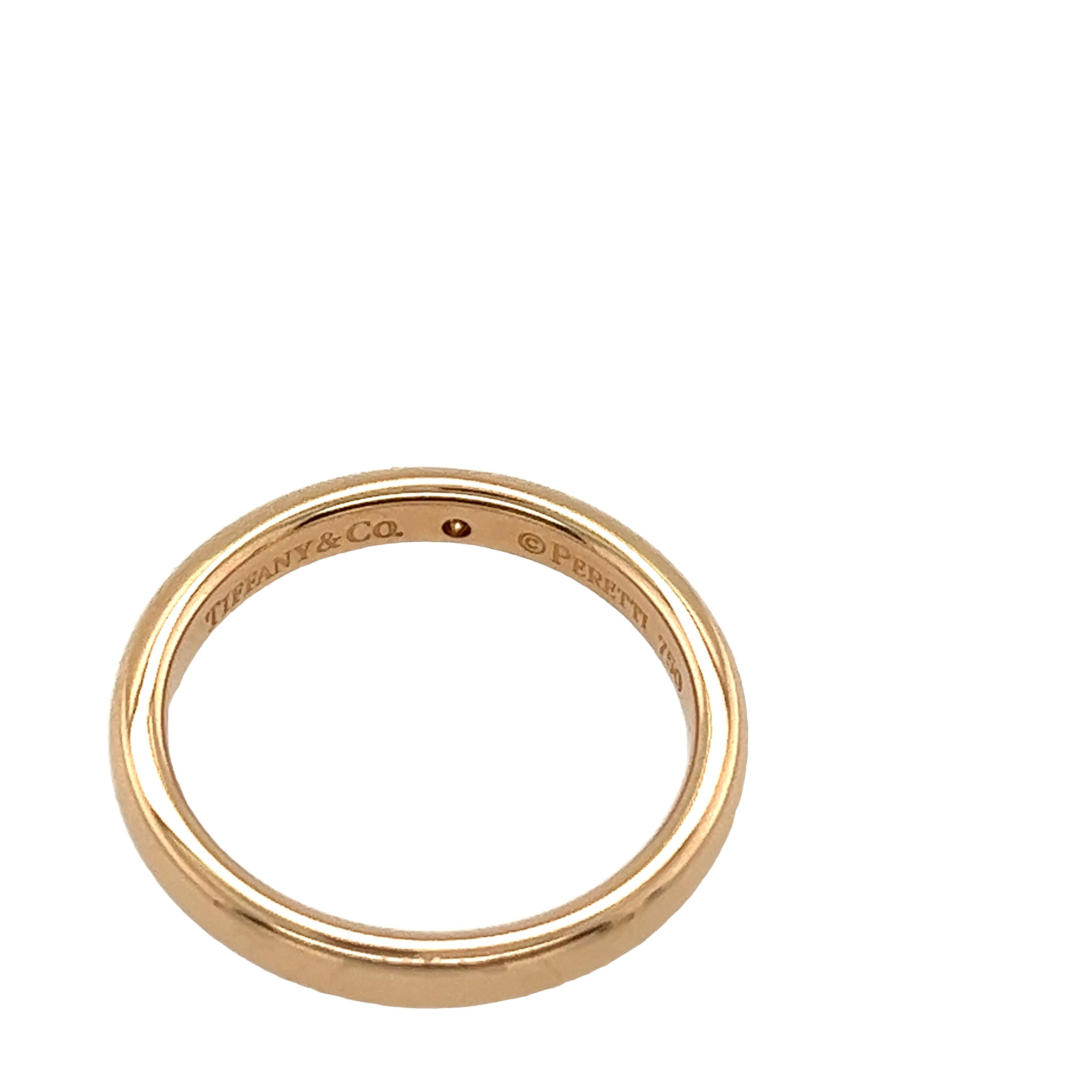 The Tiffany & Co. 18ct Rose Gold Elsa Peretti Band Ring with 1 Diamond is a stunning piece of jewellery designed by Elsa Peretti, a renowned designer known for her elegant and minimalist creations. This particular ring features a simple yet