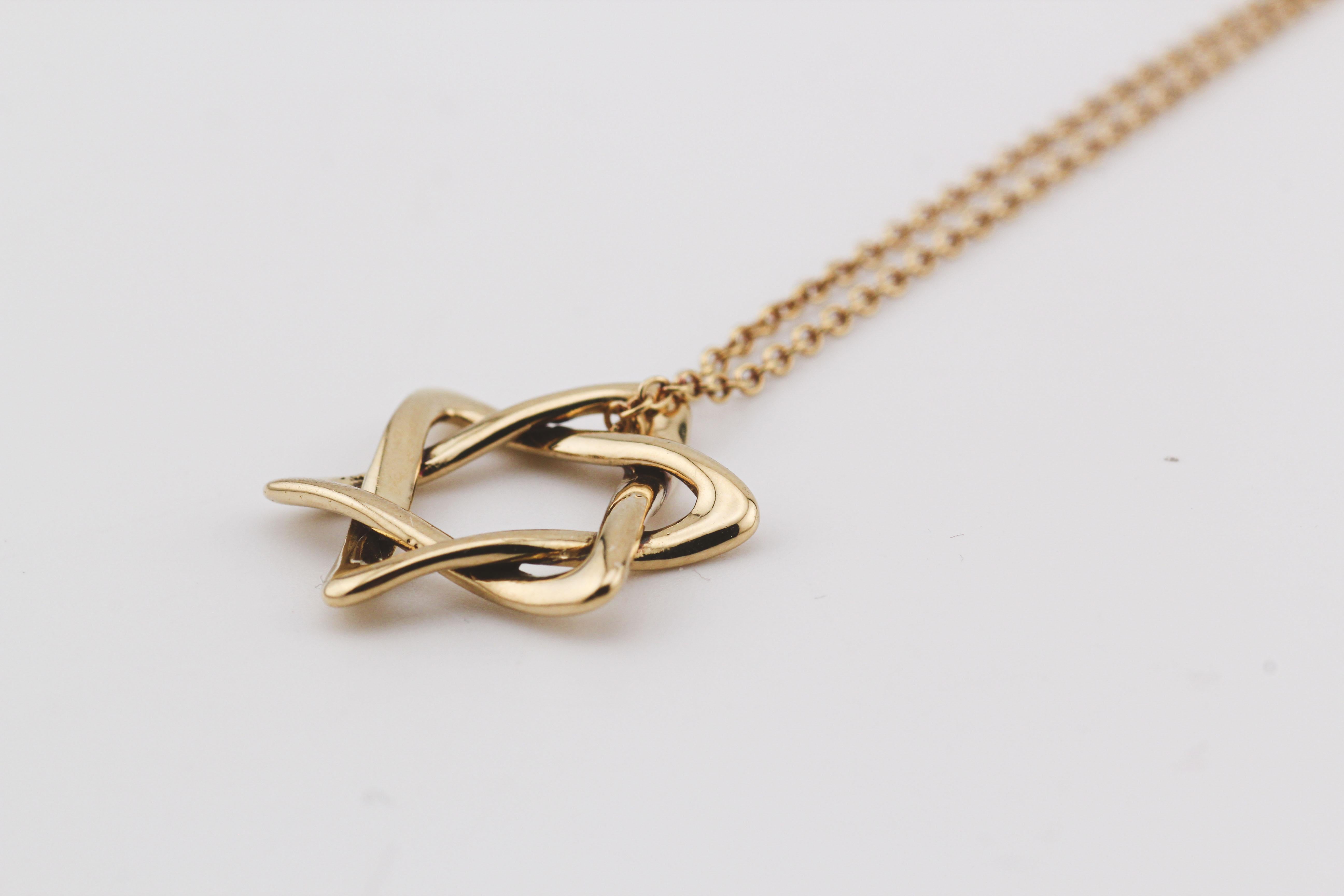 Introducing the Tiffany & Co. Elsa Peretti Star of David Large 18k Yellow Gold Pendant Necklace, a magnificent symbol of faith, artistry, and luxury. This exquisite piece of jewelry is a true masterpiece that captures the essence of timeless design
