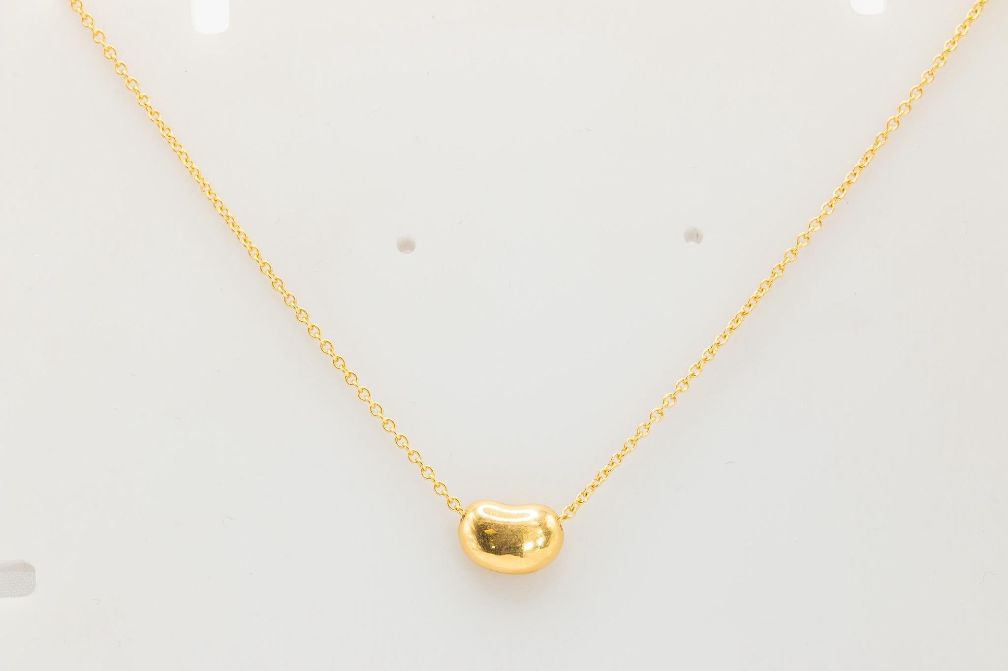 Tiffany & Co. Elsa Peretti 18K Yellow Gold Bean Pendant Necklace  

This elegant necklace features the iconic Tiffany & Co. Elsa Peretti Bean Pendant, expertly crafted in 18K yellow gold. The pendant measures 9mm and is paired with a 18K yellow gold