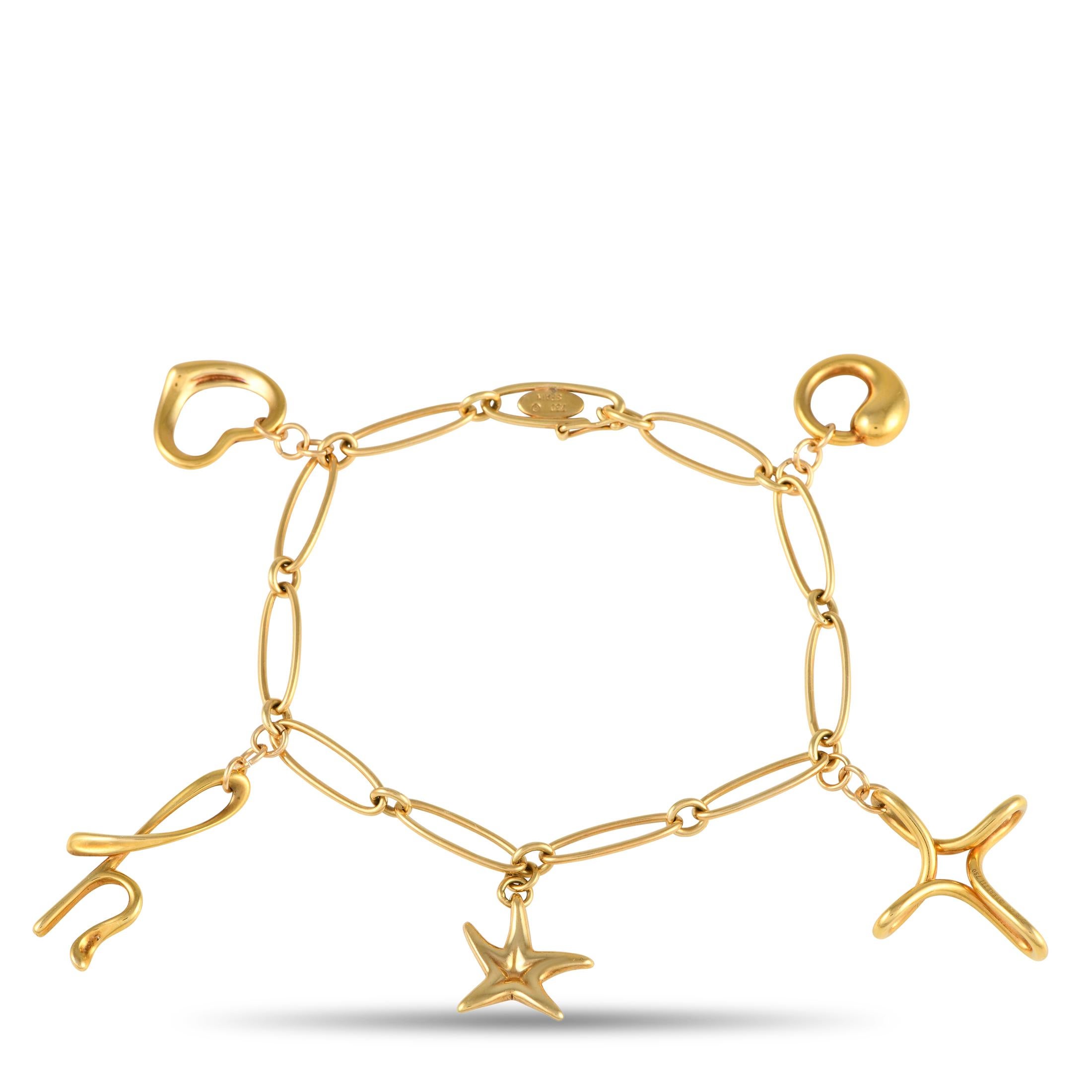 Created by Elsa Peretti at Tiffany Studios, this yellow gold bracelet exudes a youthful charm with its dainty and delicate silhouette. The rounded oval links carry five stylized solid gold charms including a starfish, a lowercase letter h, a heart,