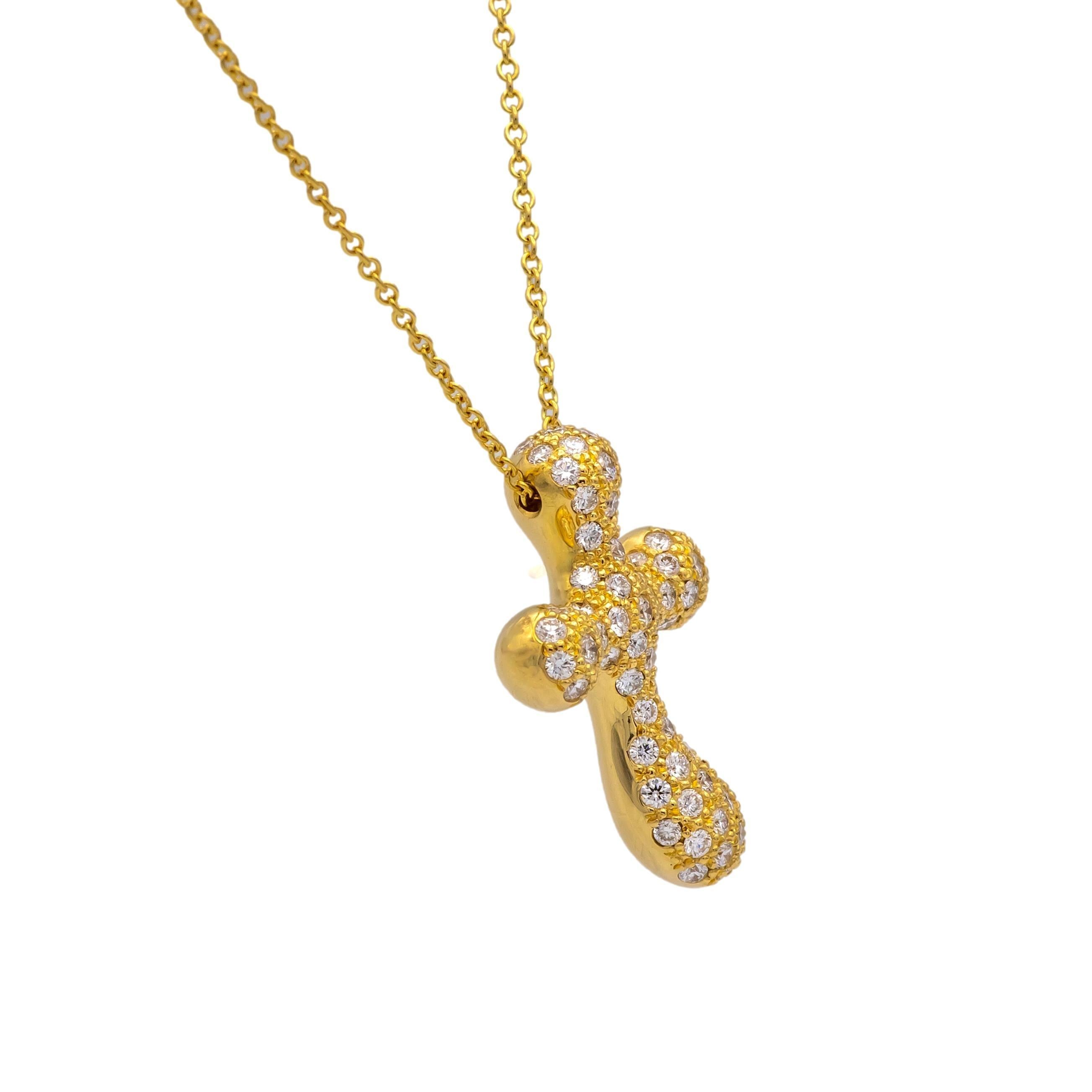 This Tiffany & Co. Elsa Peretti Cross Pendant Necklace is crafted in 18K yellow gold and features a sculptural, fluid cross design fully pavé-set with round brilliant diamonds. The pendant is suspended from an 18-inch delicate gold chain with a