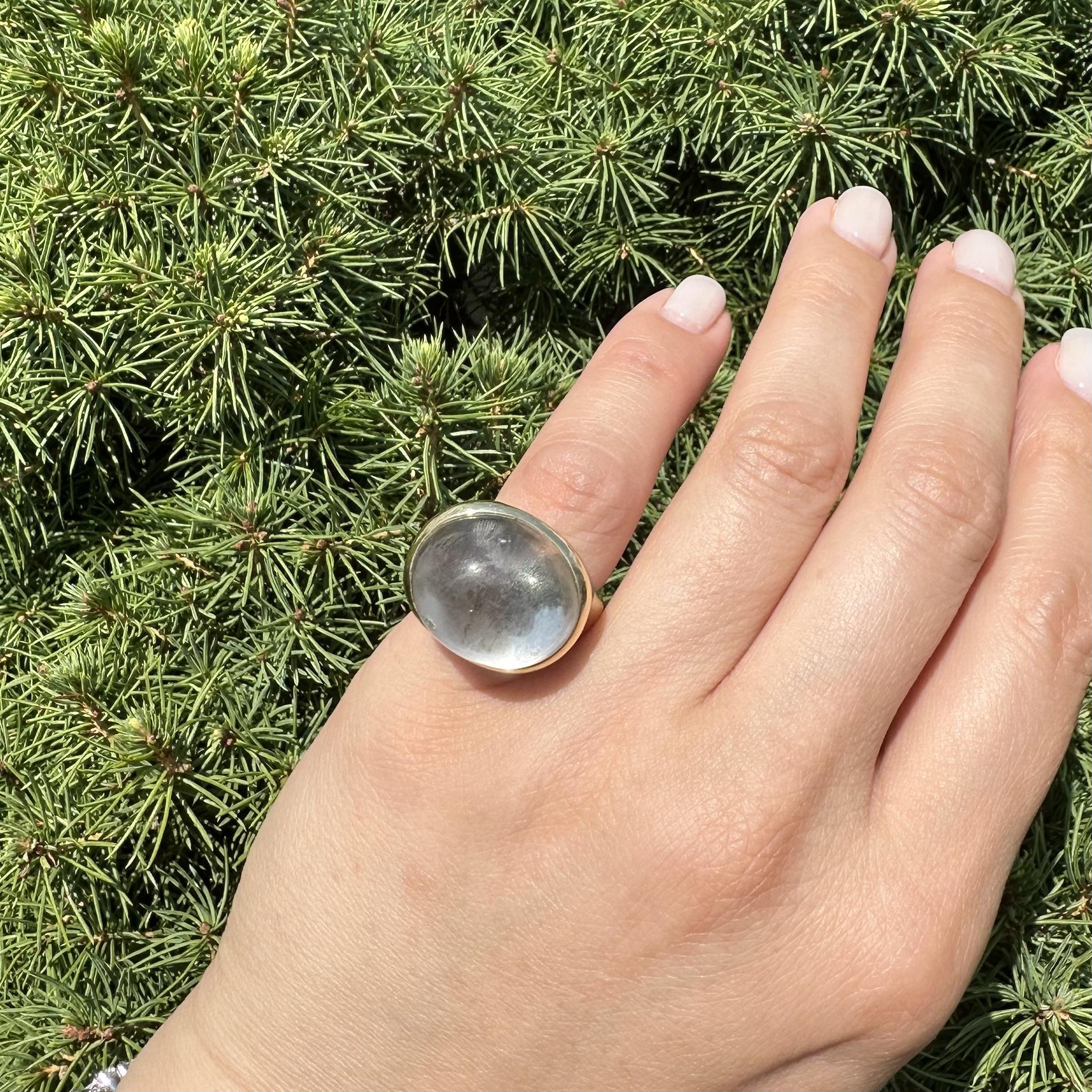 --Stone(s):--
(1) Rock Crystal Stone - Oval Cabochon Cut - Bezel Set - Clear Color - 19.5x16.9mm (approx.)

Material: Solid 18k Yellow Gold
Weight: 17.6 Grams
Ring Size: 4.5 (Fitted on a finger. We can custom size this ring.)
Ring Width: 18.3mm