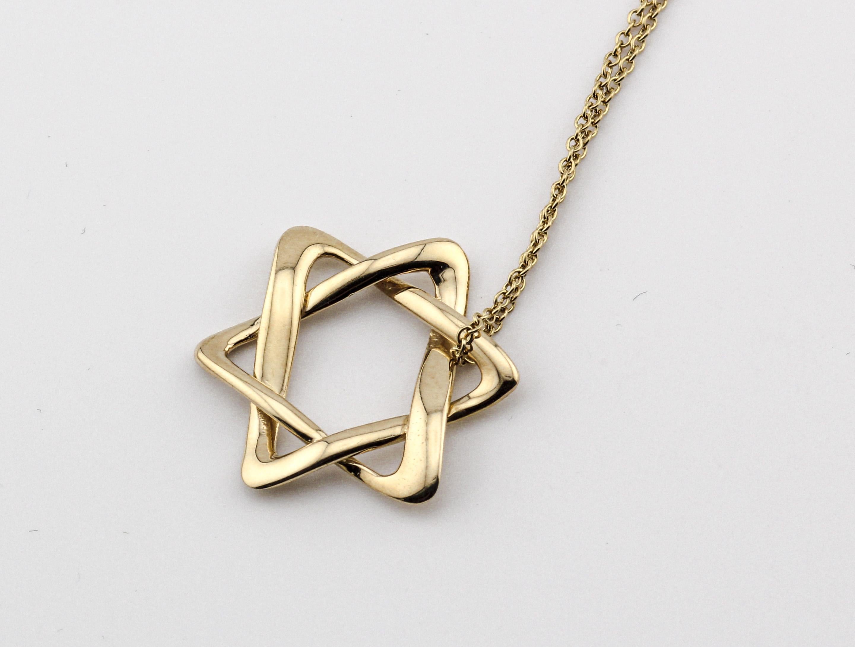 Introducing the Tiffany & Co. Elsa Peretti Star of David Large 18k Yellow Gold Pendant Necklace, a magnificent symbol of faith, artistry, and luxury. This exquisite piece of jewelry is a true masterpiece that captures the essence of timeless design