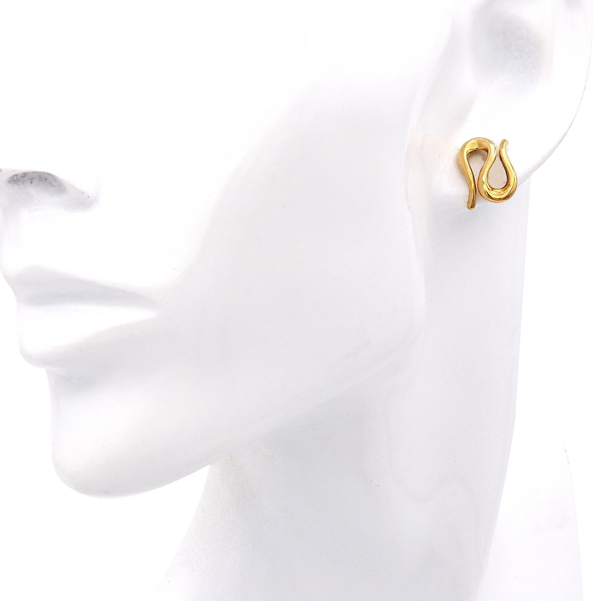 Sculptural and sensual, these Elsa Peretti Open Wave Earrings for Tiffany & Co. are a captivating embodiment of organic elegance. Crafted in rich 18K yellow gold, the fluid, abstract form reflects Peretti’s iconic design language—celebrating the