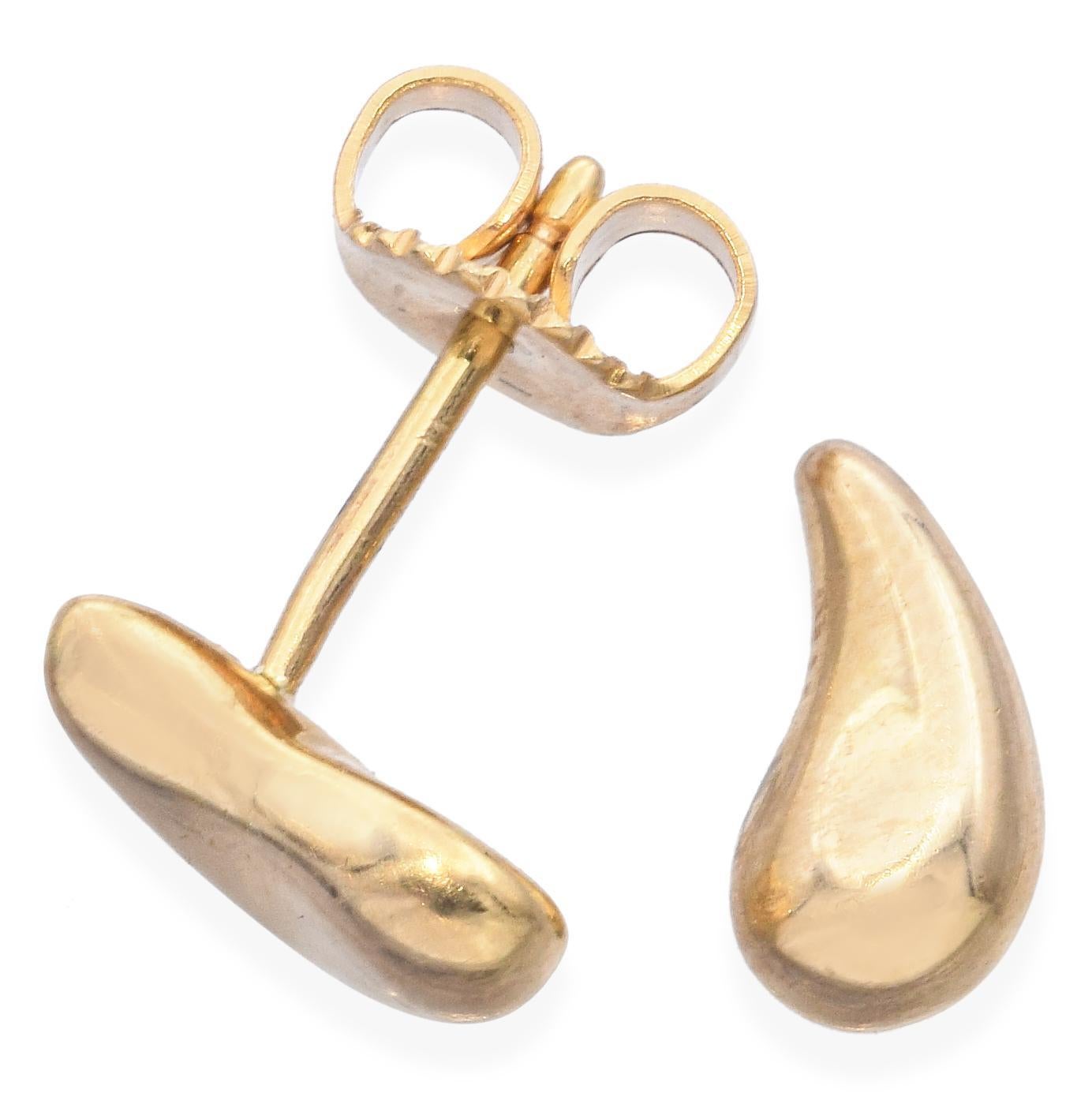 18k yellow gold Bean® earrings by Tiffany & Co. Each earring showcases a smooth, curved form with a polished finish, reflecting light beautifully. The minimalist style emphasizes the rich, warm tone of the gold. Elsa Peretti’s renowned Bean® design,