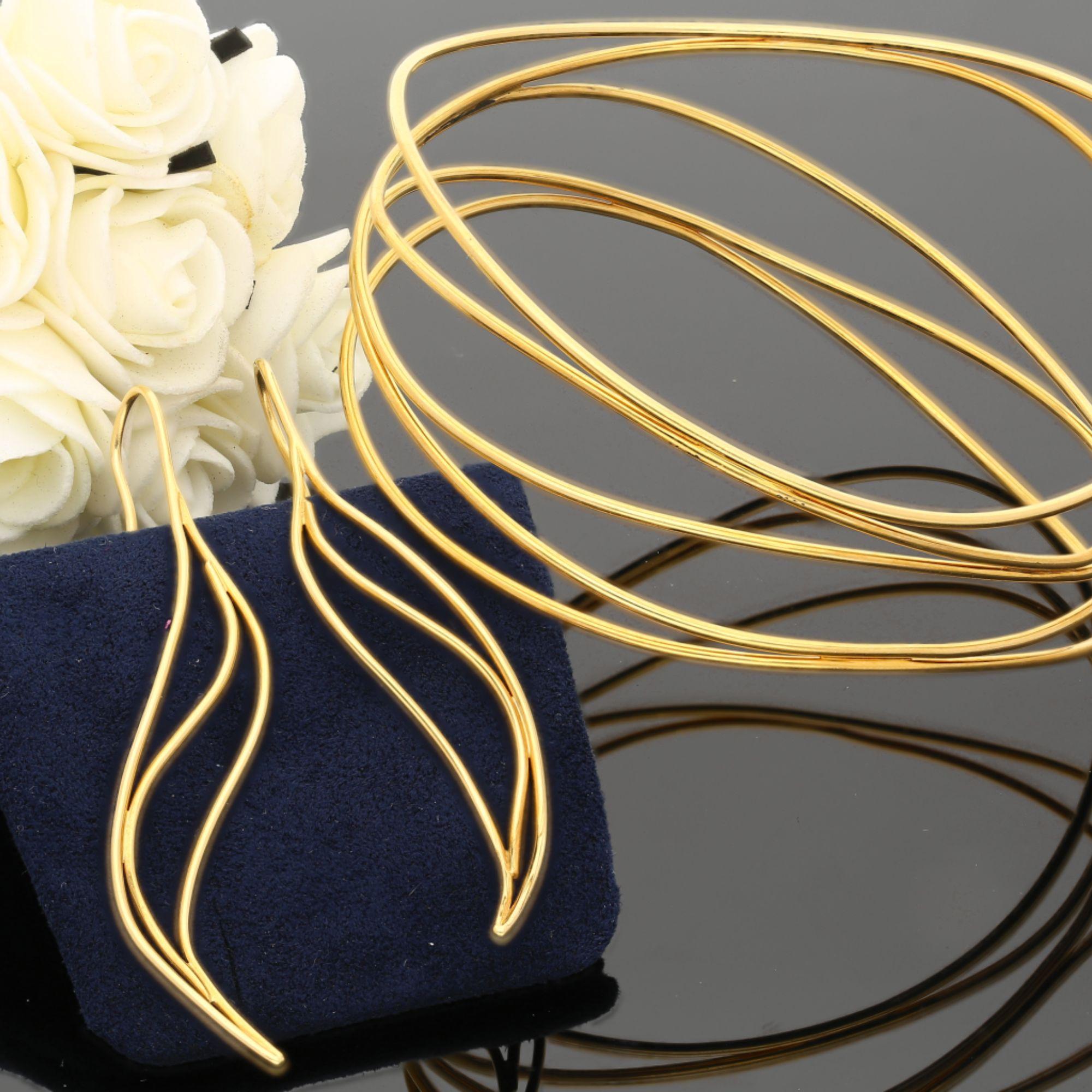 Vintage Tiffany and Co set designed by Elsa Peretti in 18K yellow gold featuring a sculptural wave bangle bracelet with flowing organic form. The bangle weighs 19.86 grams with seamless construction.

Product Specifications:
Item Type: Designer