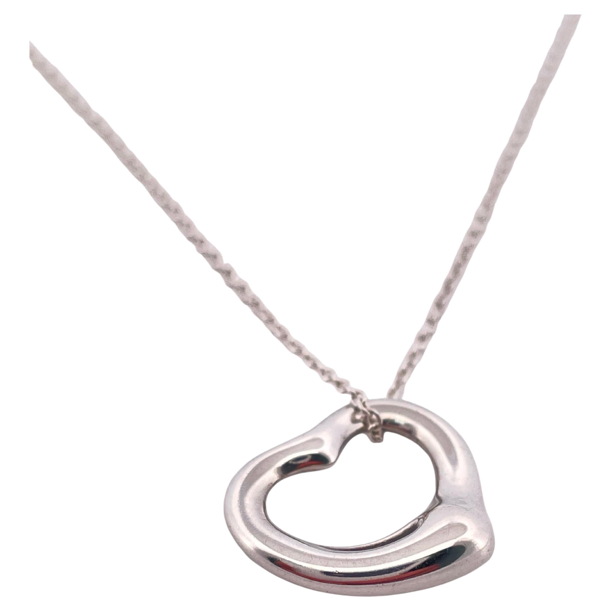 This Tiffany & Co. Elsa Peretti Open Heart pendant necklace is a timeless symbol of elegance and modern simplicity. Expertly crafted in sterling silver (.925), the iconic open-heart design reflects Peretti’s philosophy of capturing the essence of