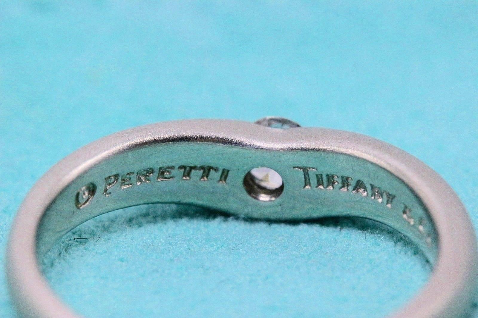 Tiffany & Co.
Style:  Elsa Peretti Curve Band Ring
Sku Number:  12060424
Metal:  Platinum PT950
Size:  8 - sizable
Total Carat Weight:  0.18 CTS
Diamond Shape:  Round Brilliant
Diamond Color & Clarity:  F / VS
Hallmark:  PERETTI
