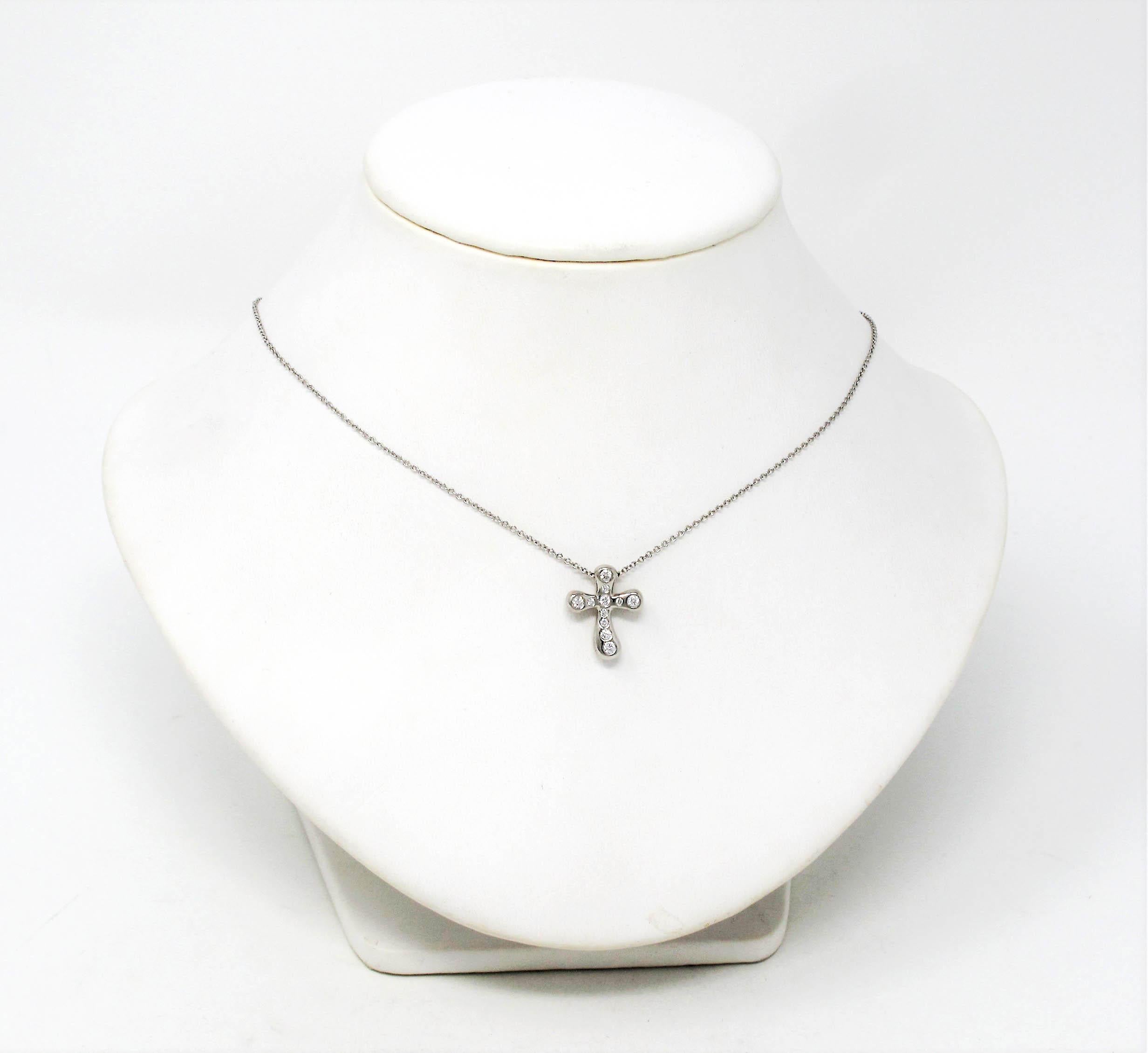 Superbe collier pendentif croix en diamant modernisé, créé par Elsa Peretti pour Tiffany & Co. Le délicat motif de la croix est orné de diamants Tiffany scintillants, tandis que la chaîne en platine finement tissée épouse délicatement le cou. Ce