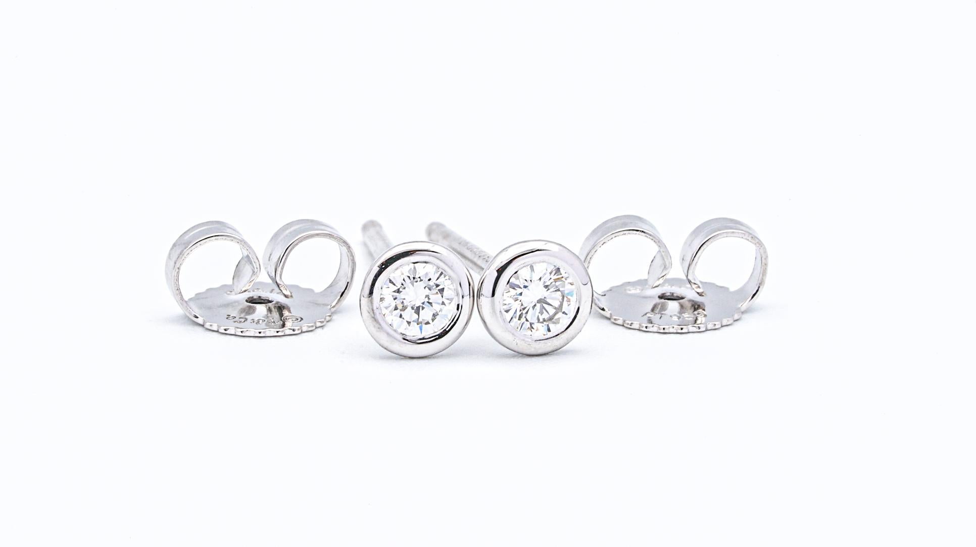 Tiffany and Co. stud earrings by Elsa  Peretti finely crafted in platinum with 2 round brilliant bezel-set diamonds weighing 0.20 cts total weight.  Pushbacks.

Stamp: T&Co.,Peretti, PT950

Free overnight delivery is available for this item.  Please