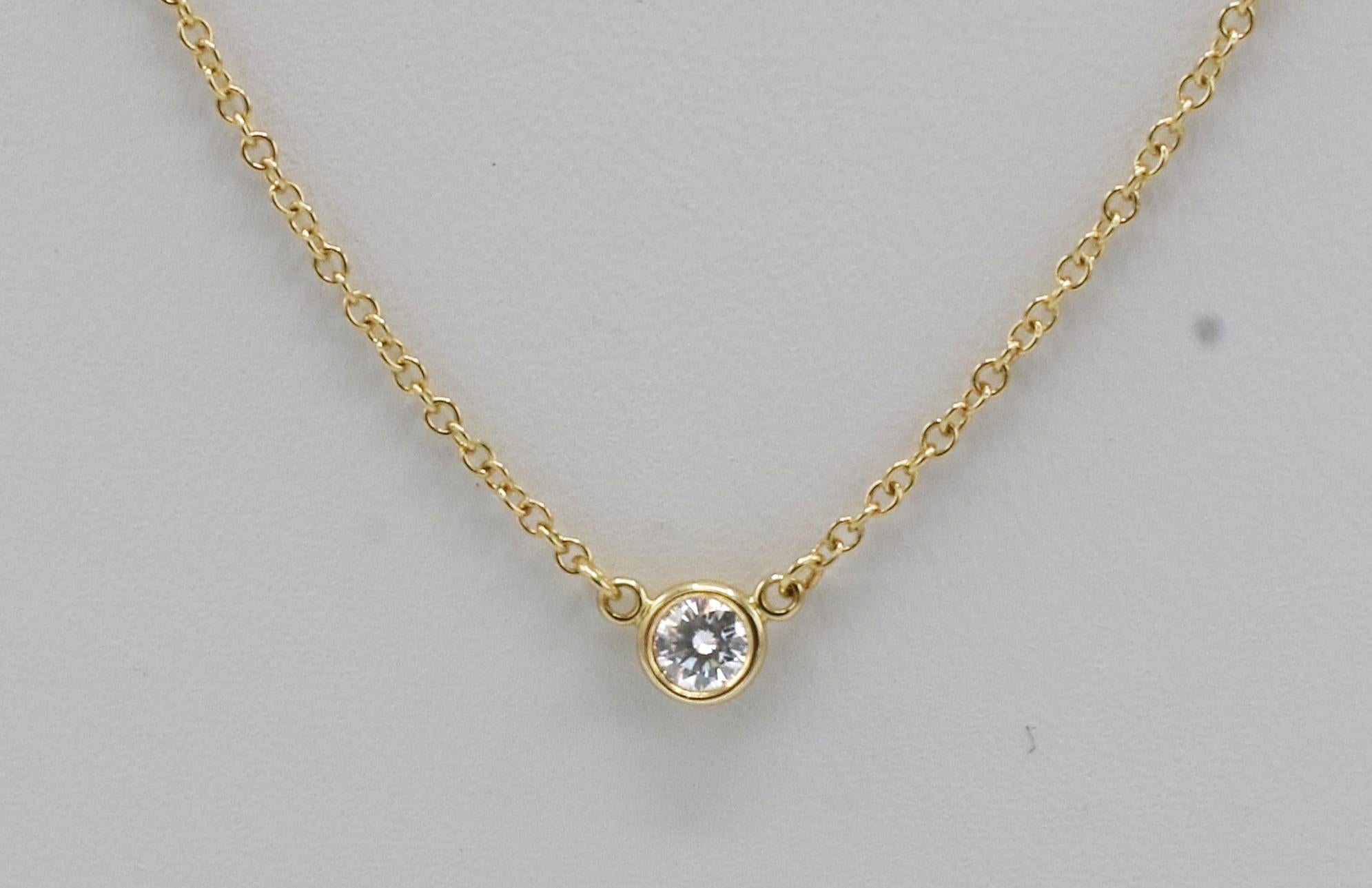Tiffany & Co. Elsa Peretti Natural Diamond By The Yard Single Pendant Necklace 
Metal: 18k yellow gold
Weight: 1.86 grams
Diamond: .12 carat F-G VS round natural diamond
Chain length: 18 inches
Retail: $1,200 USD