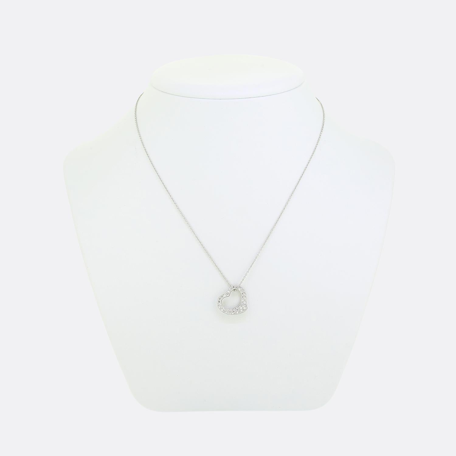 Here we have a Tiffany & Co. open heart pendant necklace. This piece forms part of an Elsa Peretti collection and is an iconic and highly recognisable design. This particular model is crafted in platinum and has been pave set with a glistening array