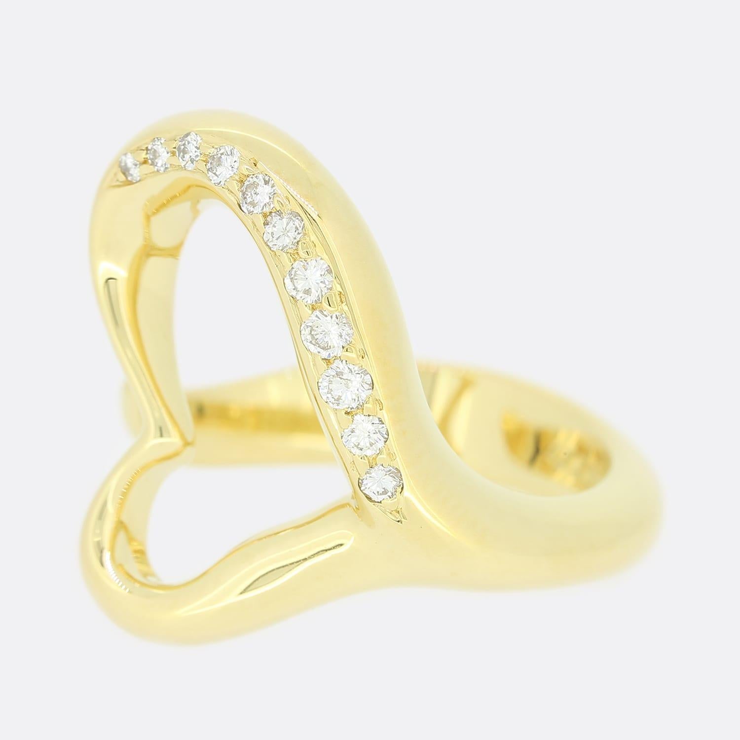 This is an 18ct yellow gold ring from the luxury jewellery designer Tiffany & Co. The ring features an open heart in the middle with a row of diamonds along one side and forms part of the Elsa Peretti collection. The simple, evocative shape of the