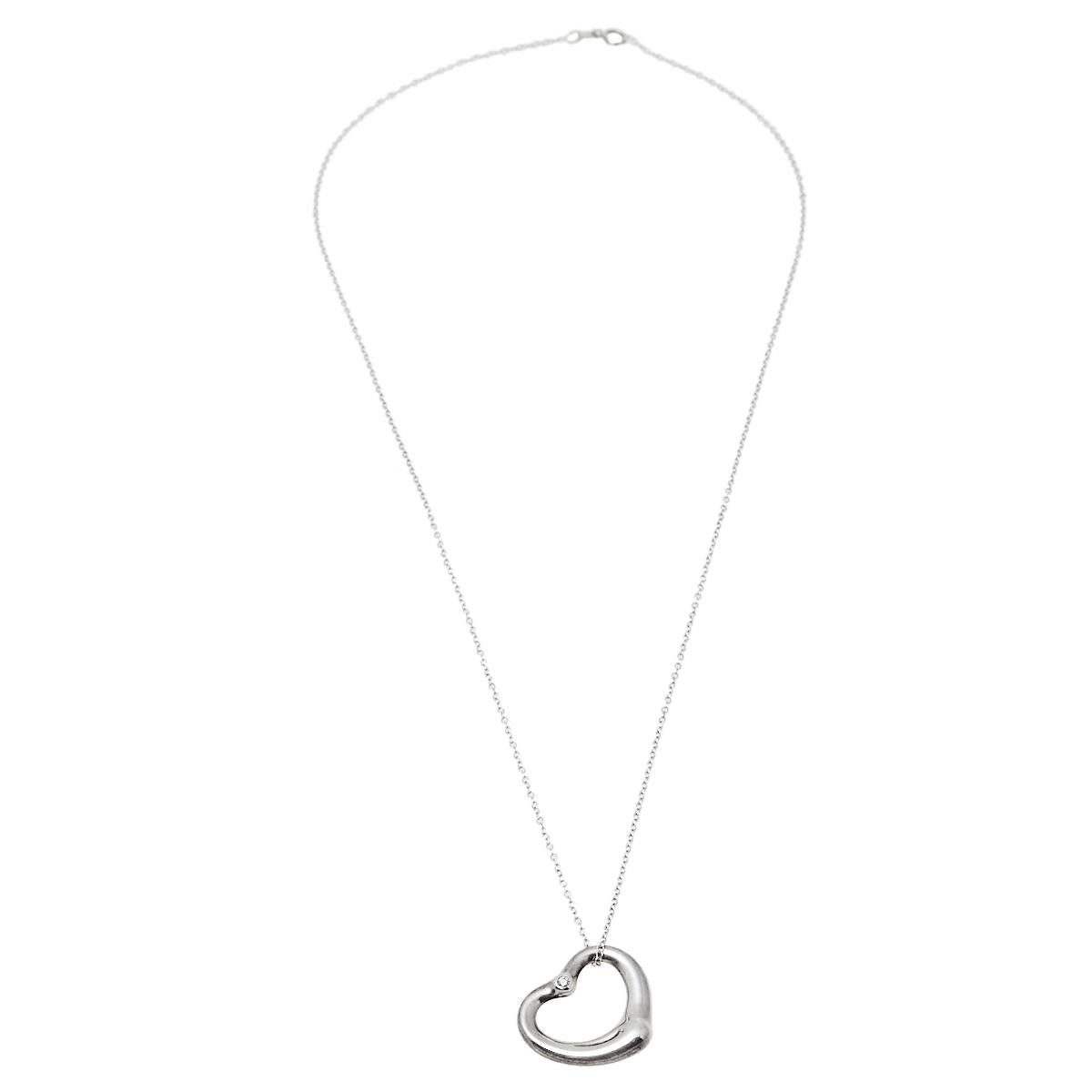 This beauty from Tiffany & Co. is exquisite and perfectly designed to last! Beautifully crafted from sterling silver, this piece is a stunner. It has been gloriously styled with an open heart pendant adorned with a diamond and is strung on a slender