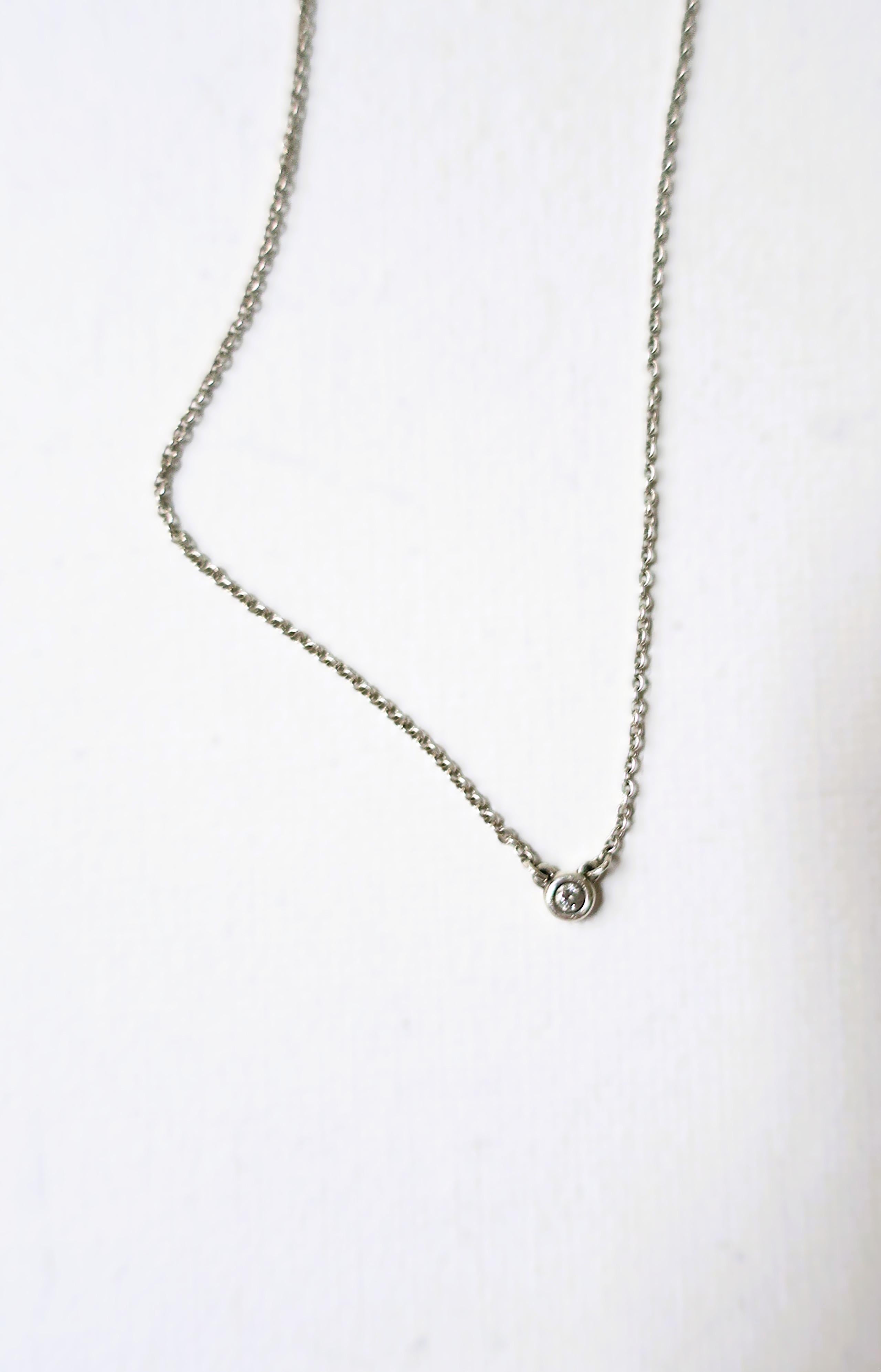 A sterling silver and genuine diamond pendant necklace from luxury retailer Tiffany & Co., by designer Elsa Peretti from the 'Diamonds by the Yard Single Diamond Pendant Necklace collection.' 