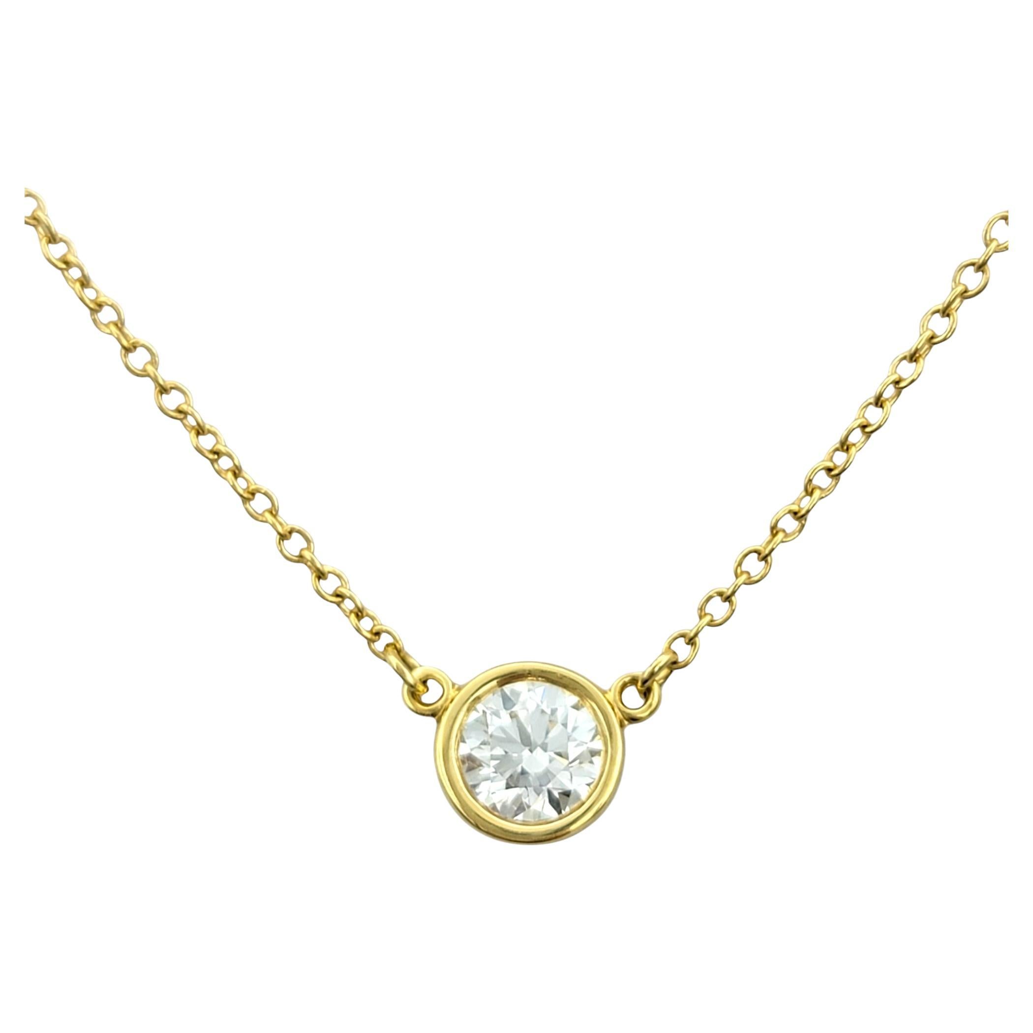 Elevate your style with this Tiffany & Co. Diamonds by the Yard  necklace, designed by the legendary Elsa Peretti. Crafted in radiant 18 karat yellow gold, this piece exudes timeless elegance and modern sophistication. At its heart lies a bezel-set
