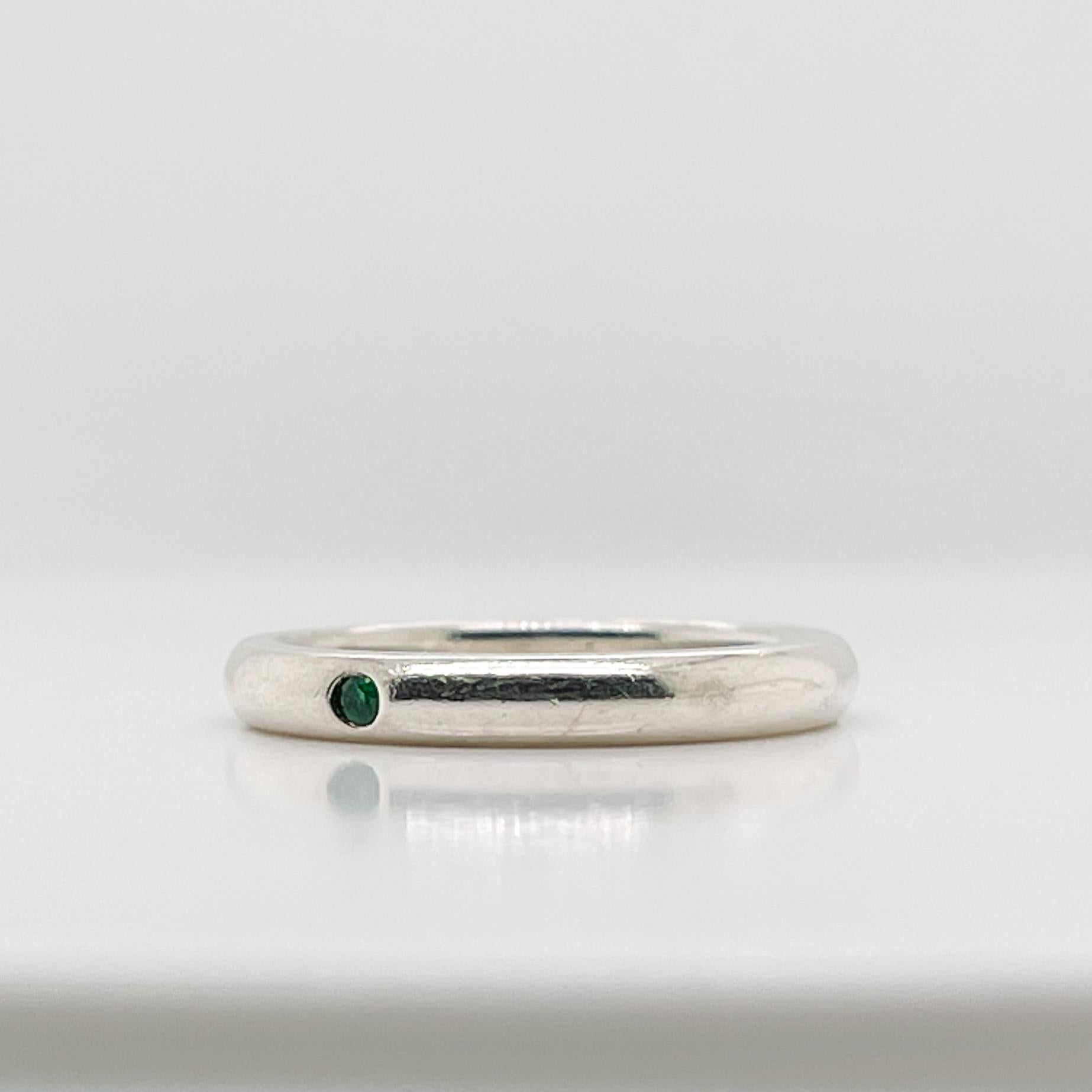 A very fine Tiffany & Co. stackable sterling silver ring.	

By Elsa Peretti. 

Flush set with a round cut emerald.

Perfect, Simple, Refined.

Date:
20th Century

Overall Condition:
It is in overall good, as-pictured, used estate condition with some