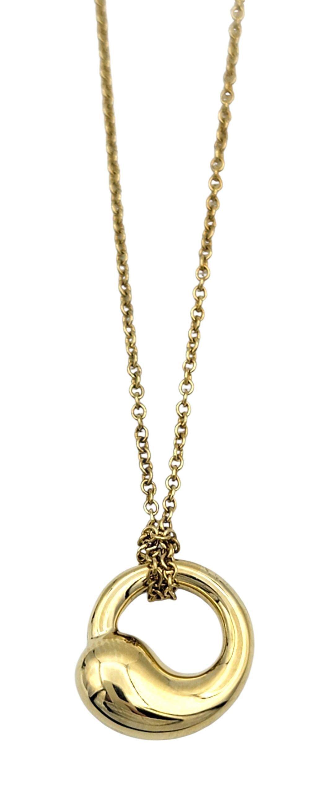 This elegant necklace from Elsa Peretti for Tiffany & Co. features the iconic Eternal Circle pendant, crafted in warm 18 karat yellow gold. Suspended from an 18-inch chain, the pendant showcases Peretti’s signature organic design, with a smooth,